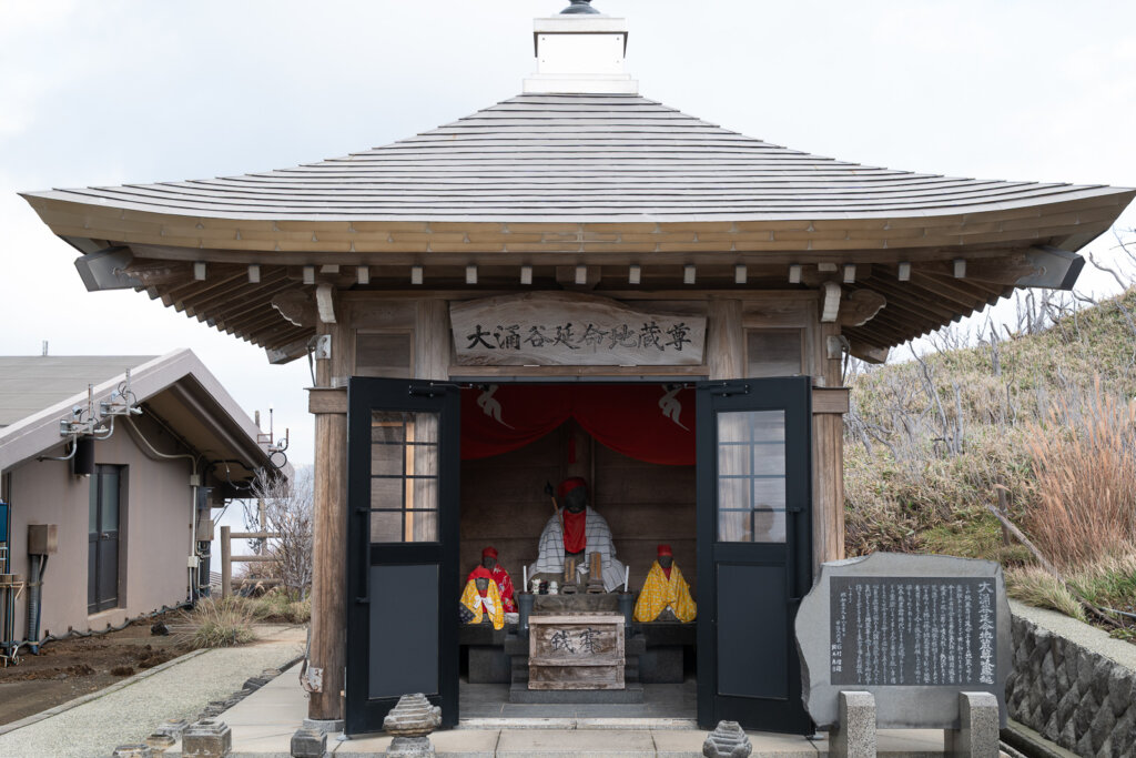 Small shrine near the Owakudani viewing area, set against the volcanic landscape.