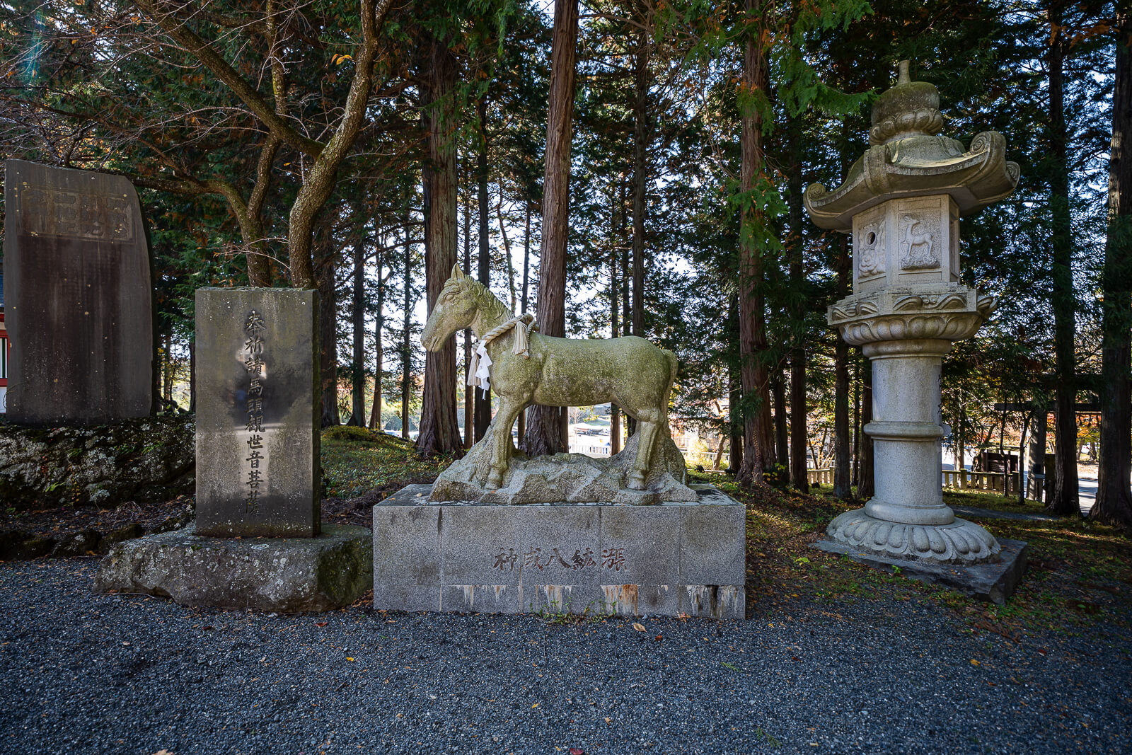 Stone horse beside a lantern among trees at Fuji Omuro Sengen Shrine