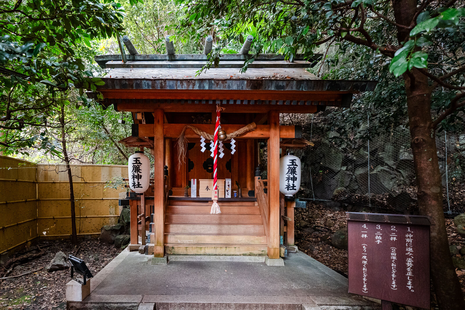 Small Tamadare Shrine building set against the wooded hillside above Tenseien Garden in Hakone-Yumoto.