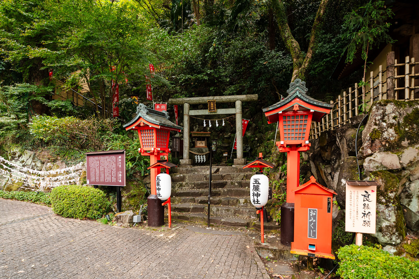 Tamadare Shrine area in Tenseien Garden with small shrine structures, stonework, and red accents beside the path.