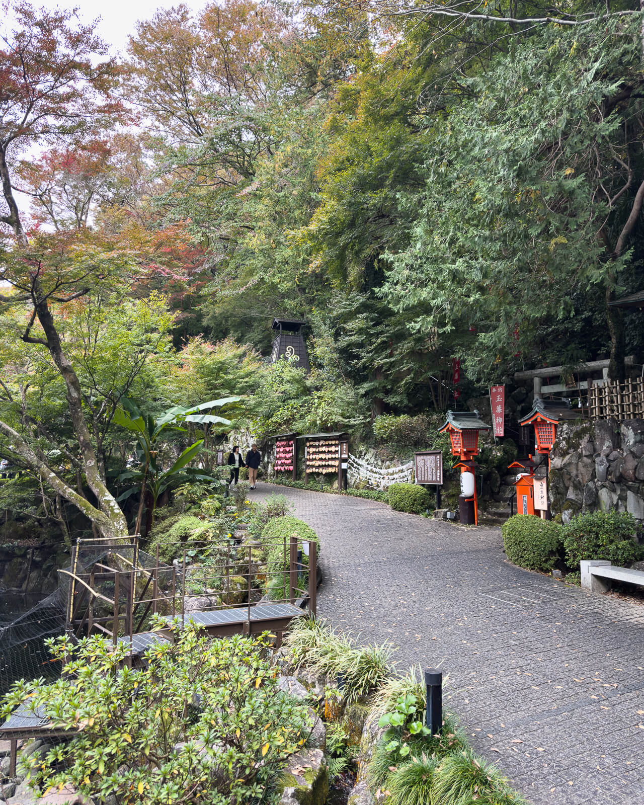 Main walking path through Tenseien Garden bordered by trees, rocks, moss, and landscaped greenery.