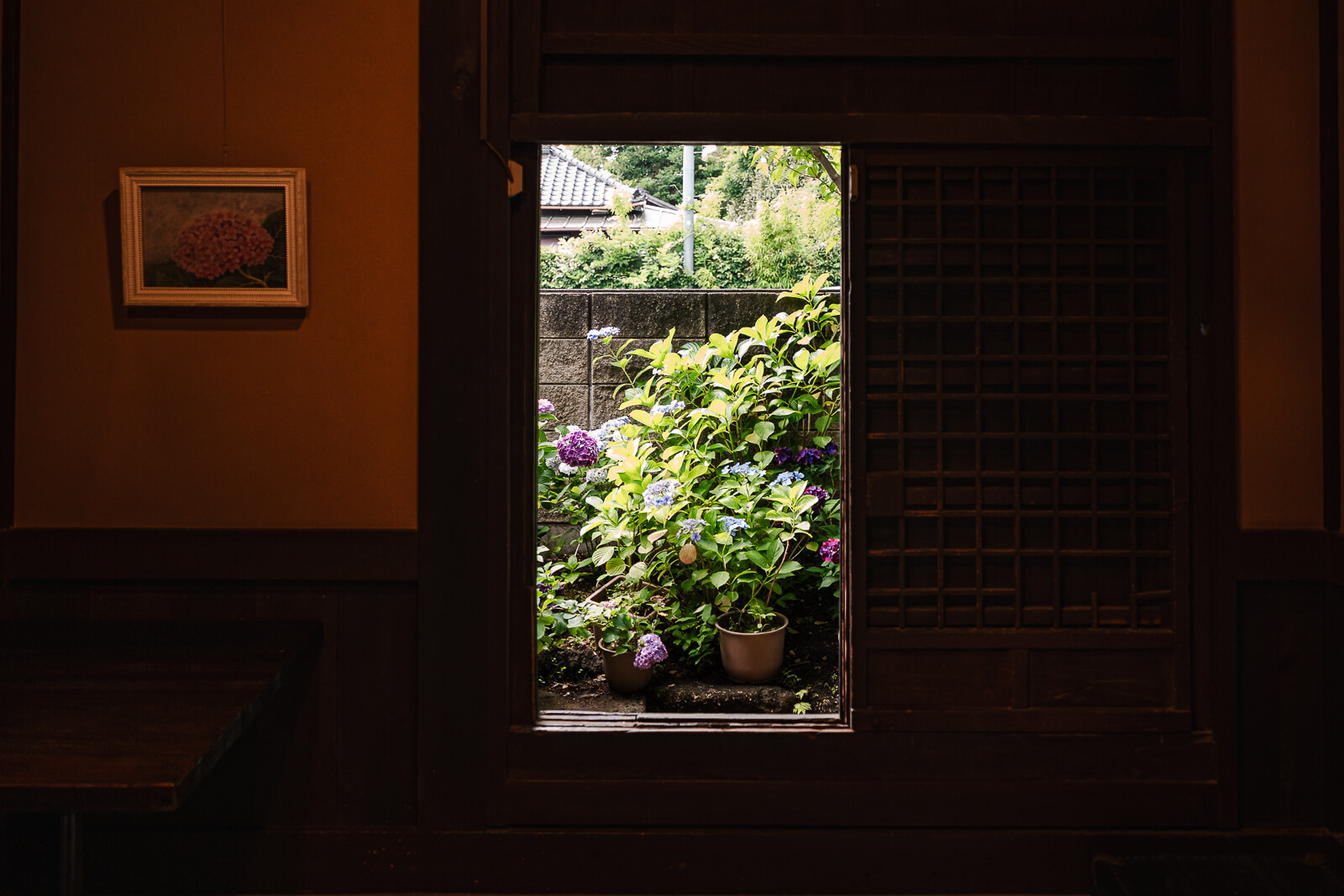 Garden view framed by a traditional window inside the Kitakamakura Old Folk House Museum