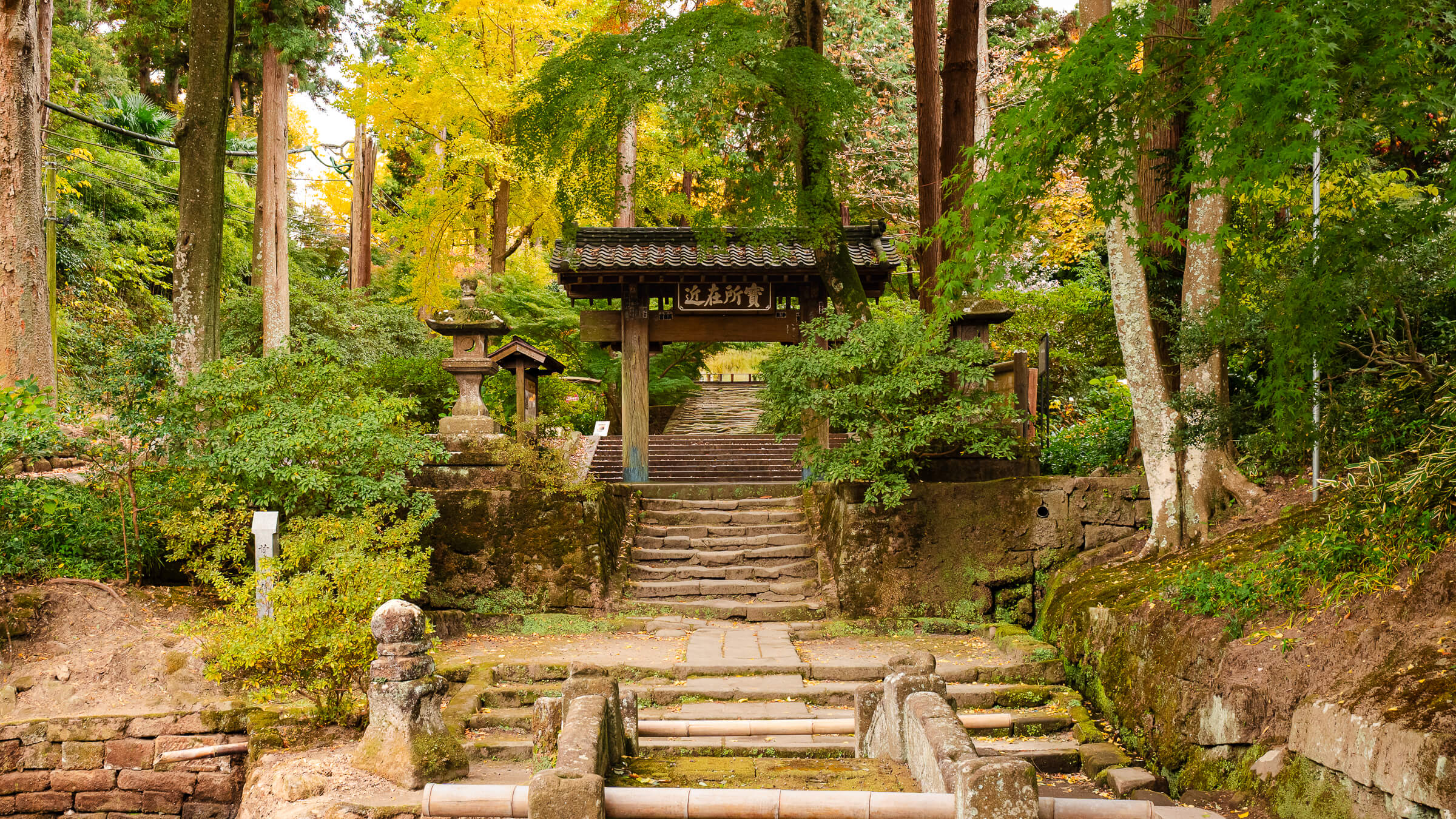 Stone bridge leading to the Sanmon gate at Jōchi-ji Temple in Kita-Kamakura during peak autumn