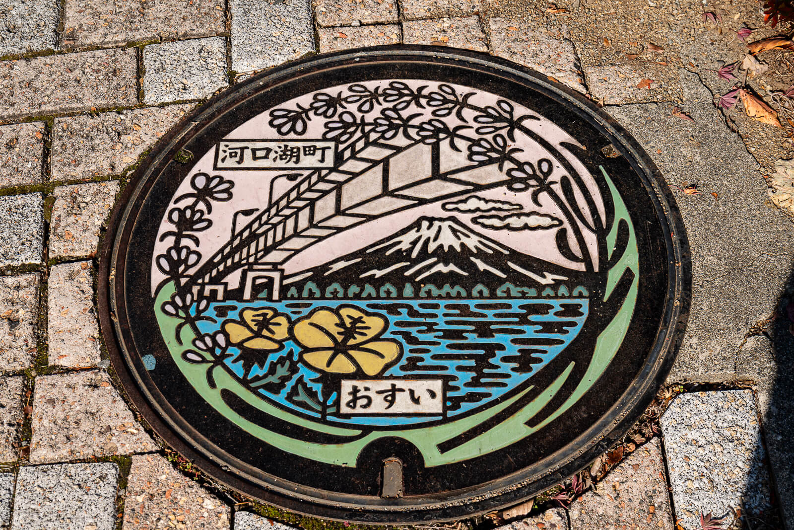Decorative Mount Fuji and lake manhole cover at Kawaguchiko Maple Corridor area