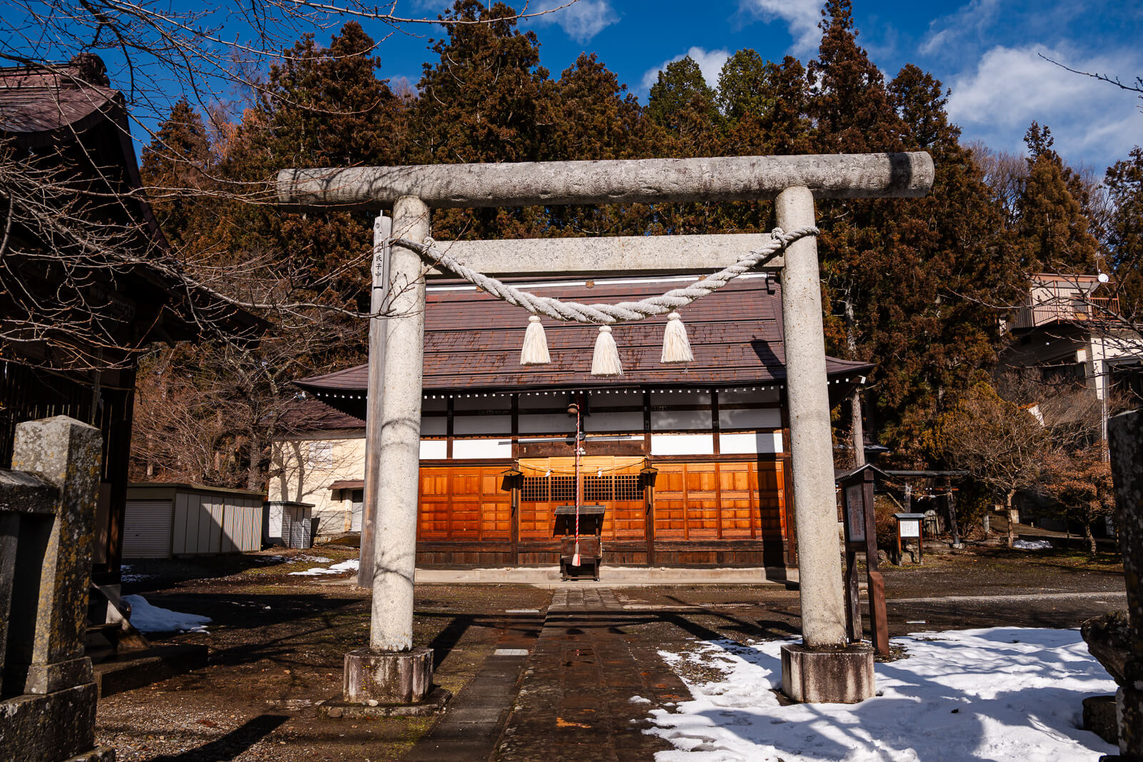 Small temple structure in Yudanaka Onsen with light winter snow