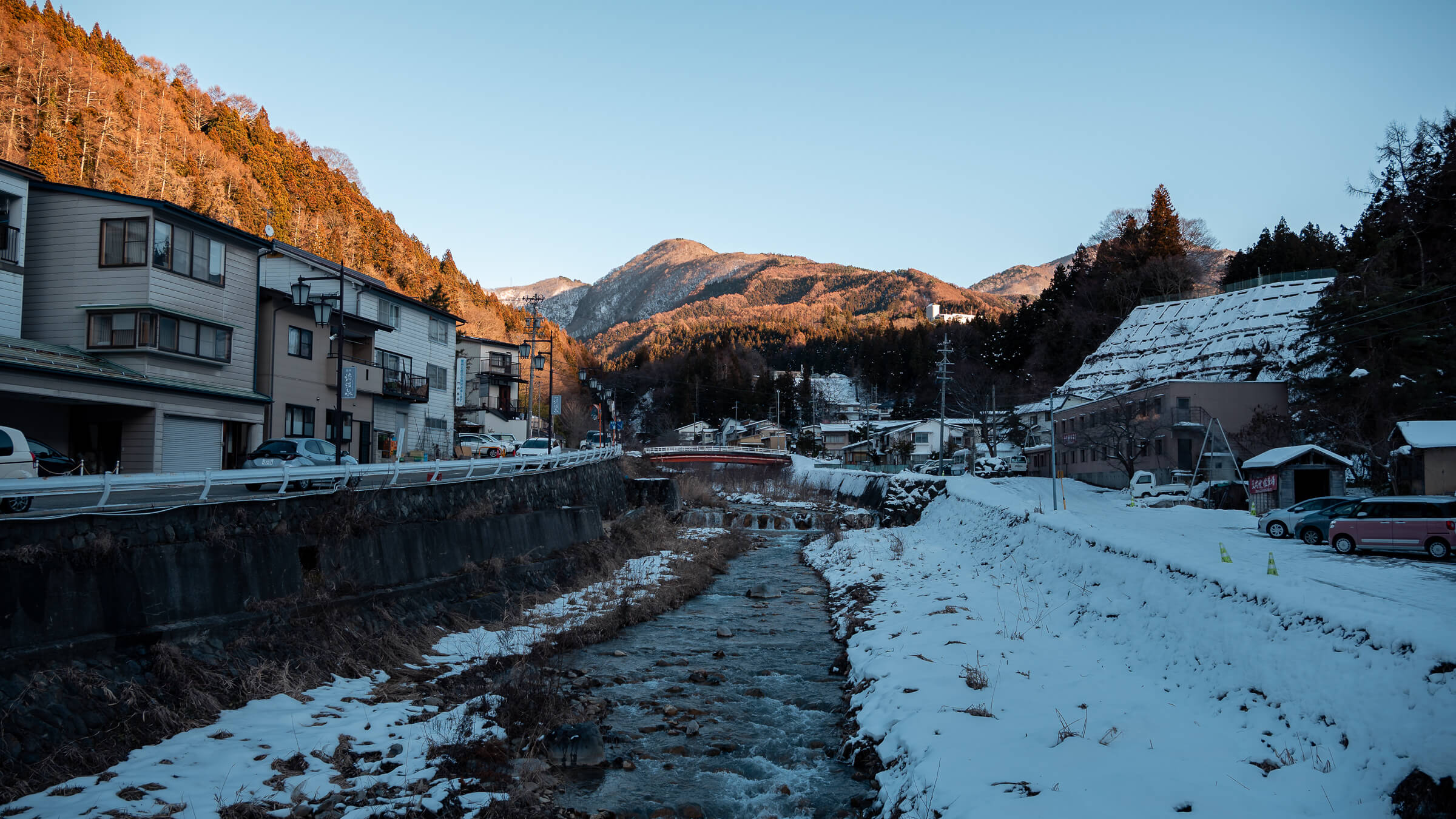 Snow-covered Shibu Onsen in Nagano Prefecture with mountain backdrop and late afternoon winter light