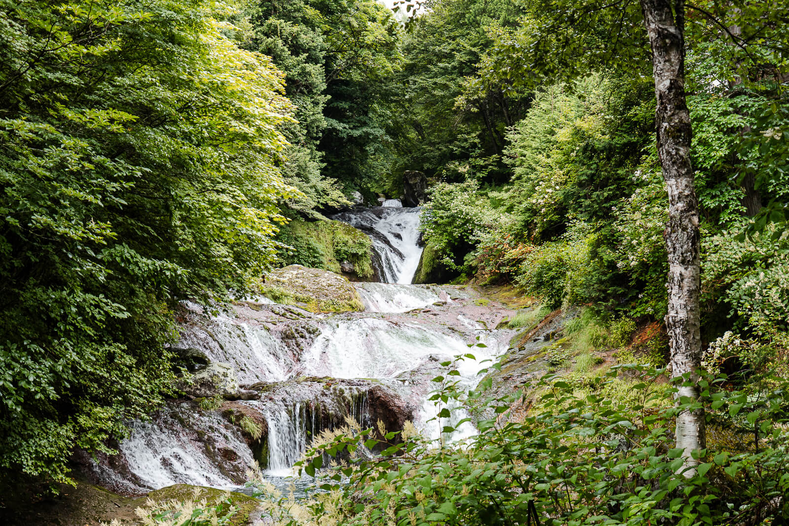 Cascades of Oshidori Kakushi Falls along the steep road below Mishaka-ike Pond in Chino Nagano