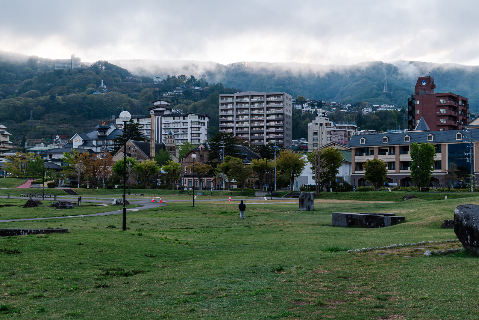 Lakeside park with buildings and shoreline at Lake Suwa