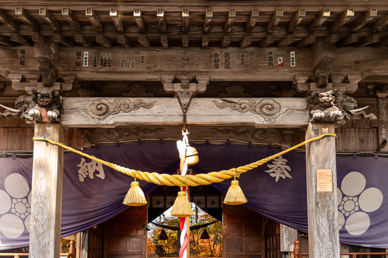 Carved eaves, bell rope and purple curtains at Hirano Tenmangu