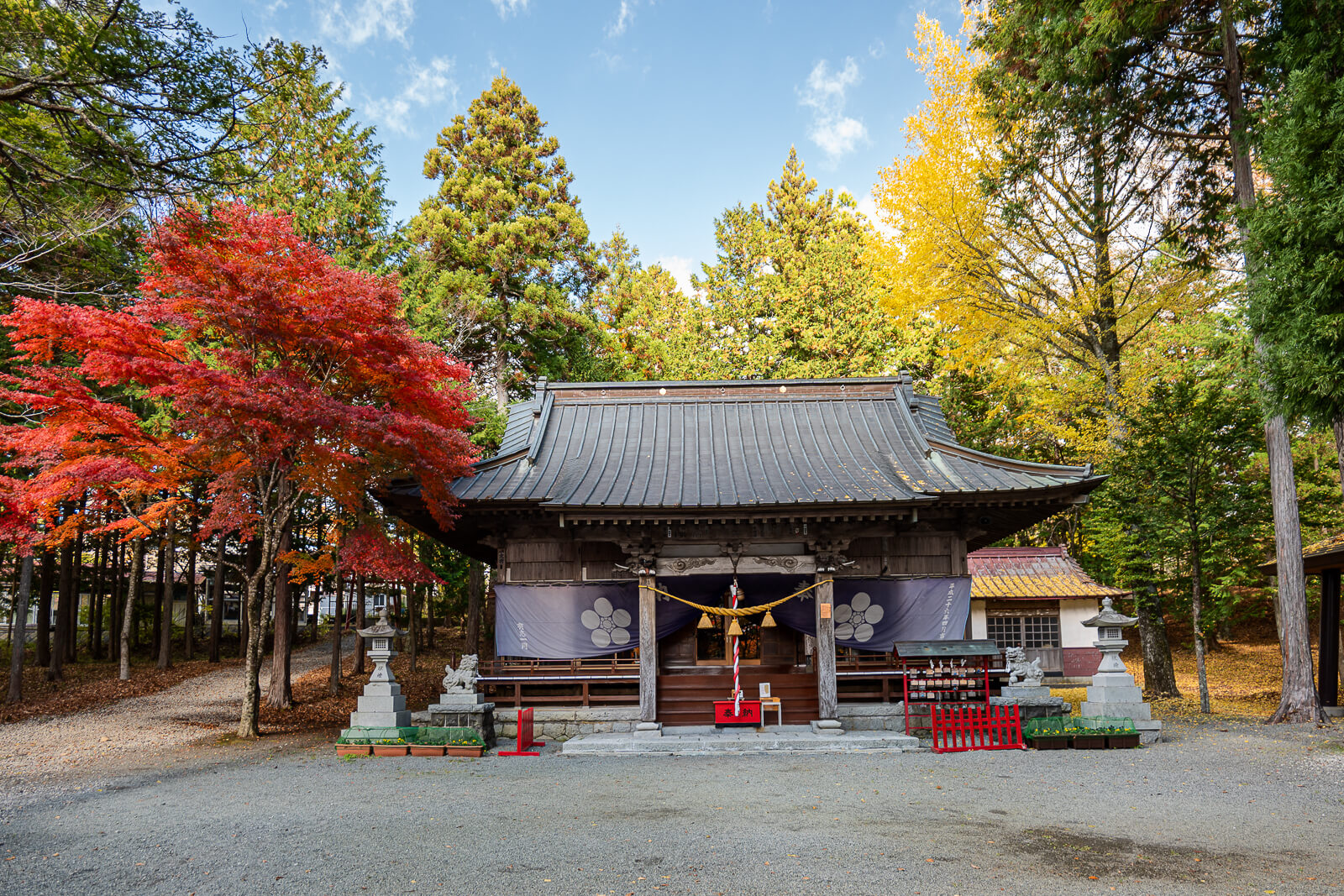 Hall and courtyard between red and yellow foliage at Hirano Tenmangu