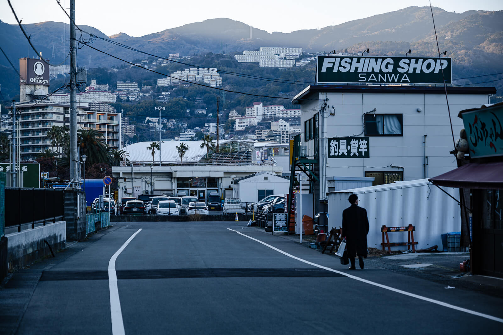 Harbor port area in Atami with street view toward the waterfront and surrounding hillside buildings