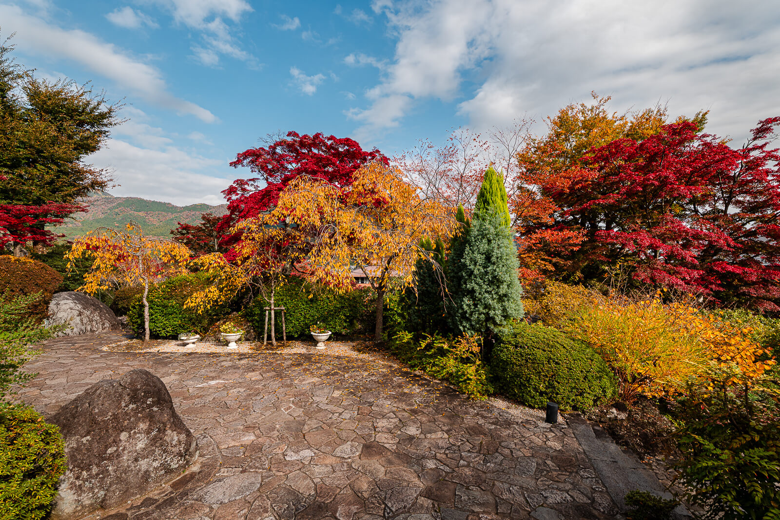 Central fountain surrounded by autumn foliage and landscaped gardens at Gora Park in Hakone