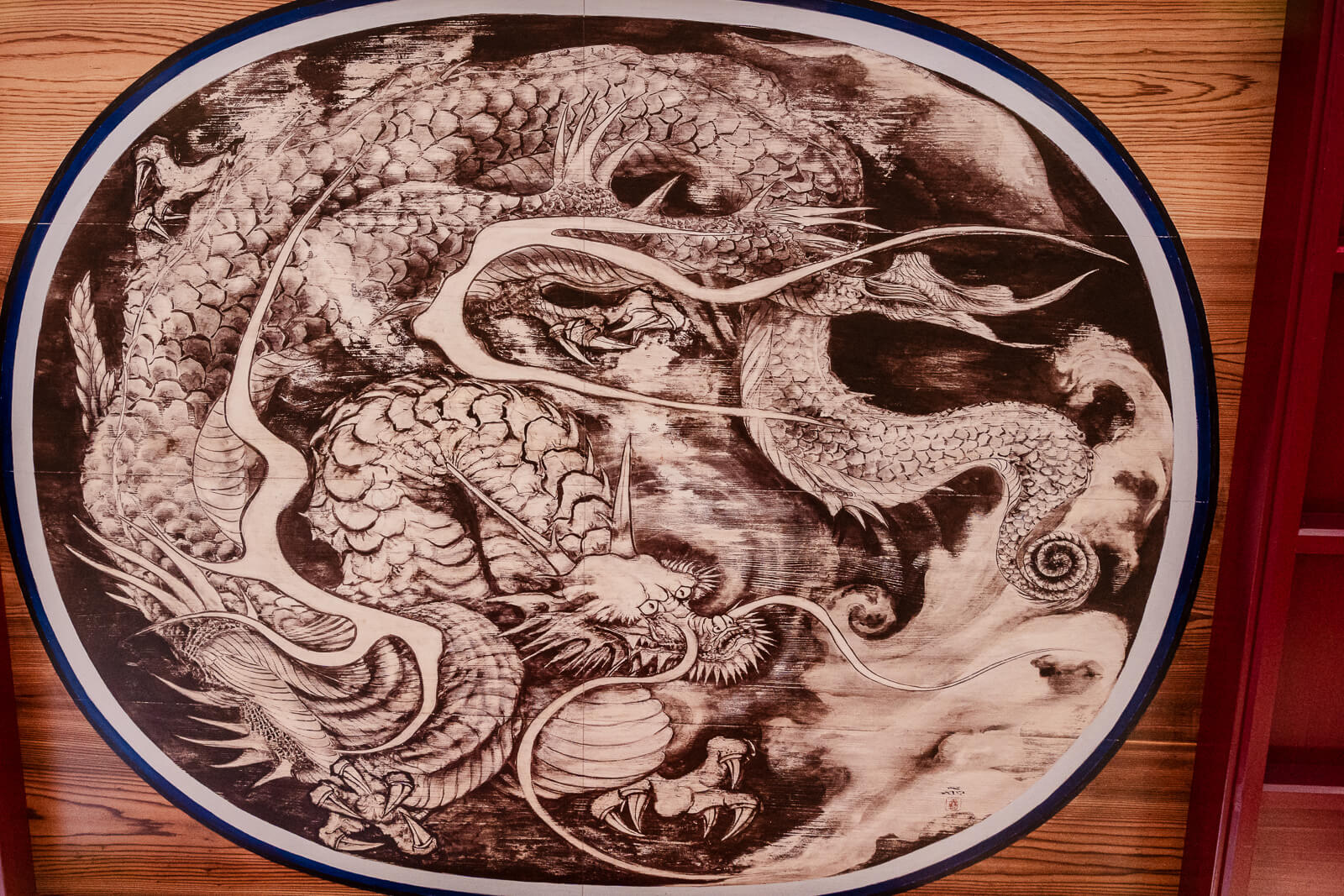 Circular relief of a coiled dragon with curling decorative patterns at Hakone Shrine in Motohakone