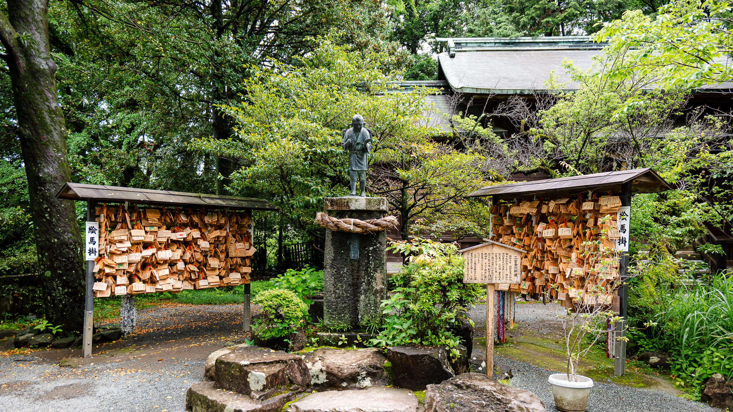 Statue of Ninomiya Sontoku at Hotoku Ninomiya Shrine in Odawara surrounded by ema prayer boards and trees