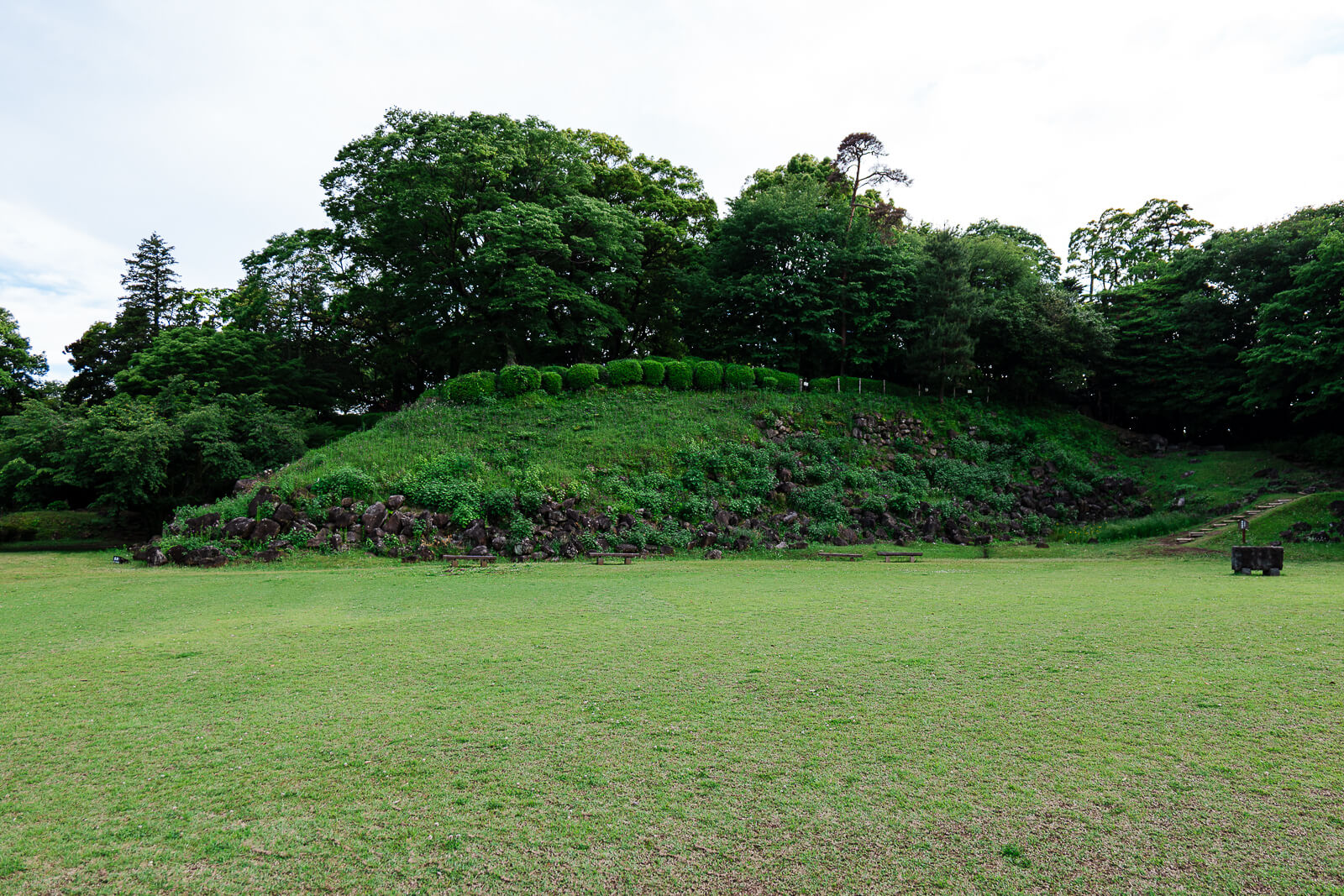 Grassy clearing and raised earthwork at Ishigakiyama Castle Ruins in Odawara