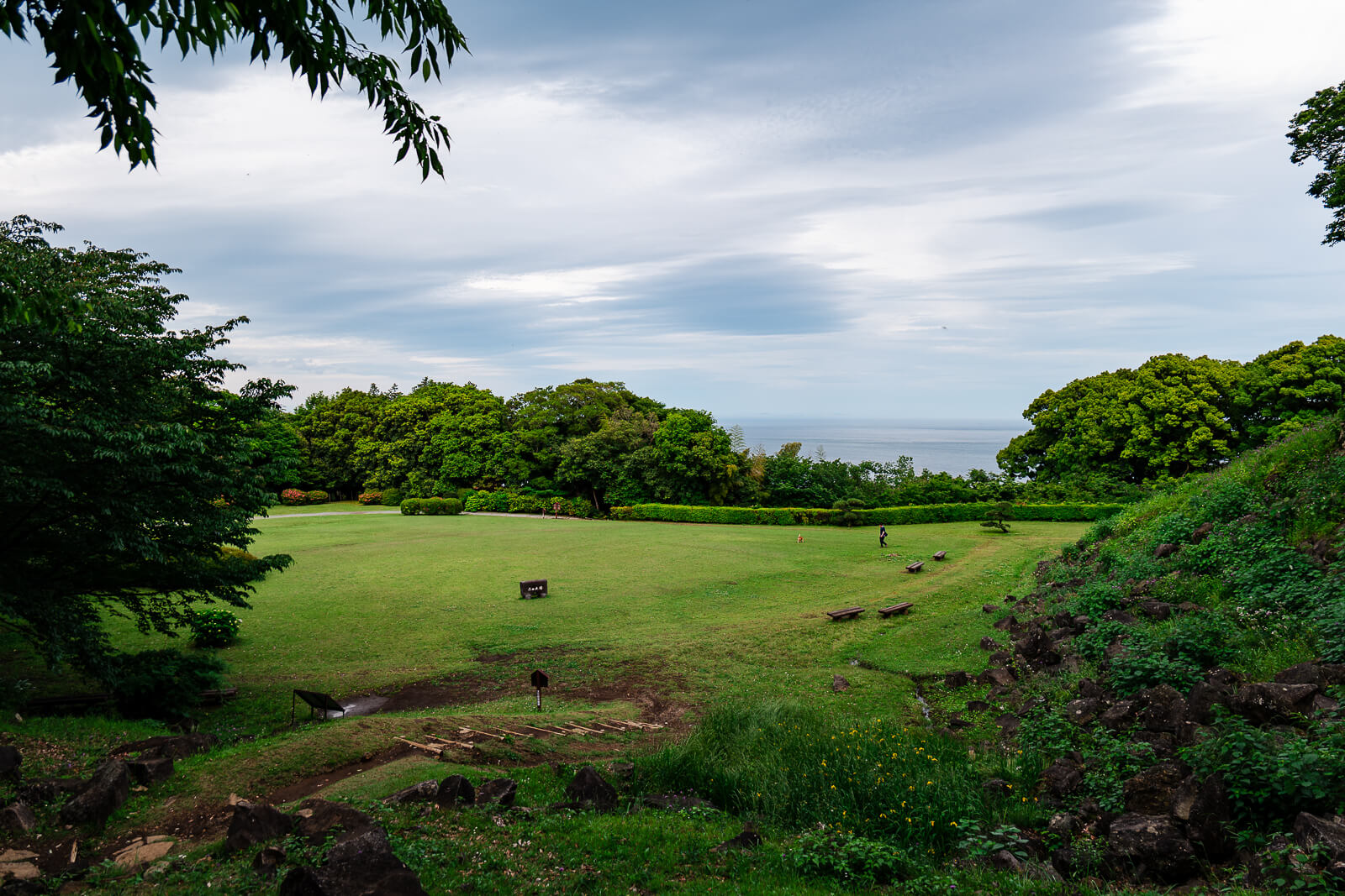 Open grassy area and earthworks at Ishigakiyama Castle Ruins in Odawara