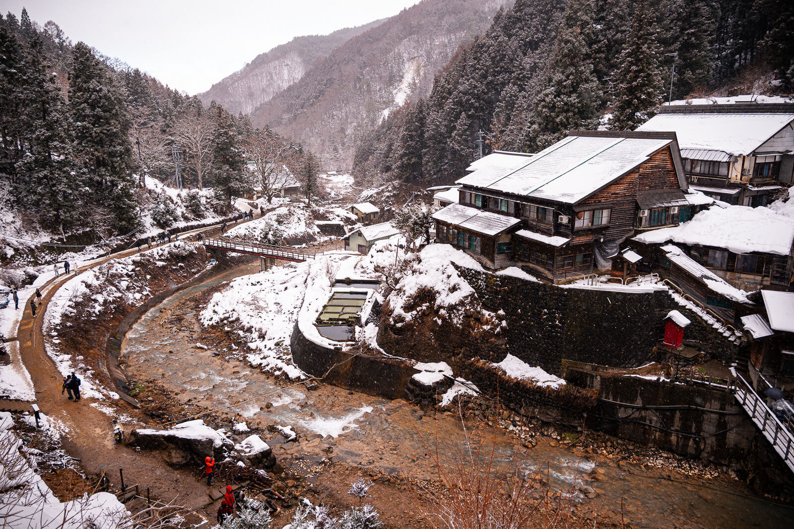Snow-covered buildings and river valley near Jigokudani Monkey Park in winter