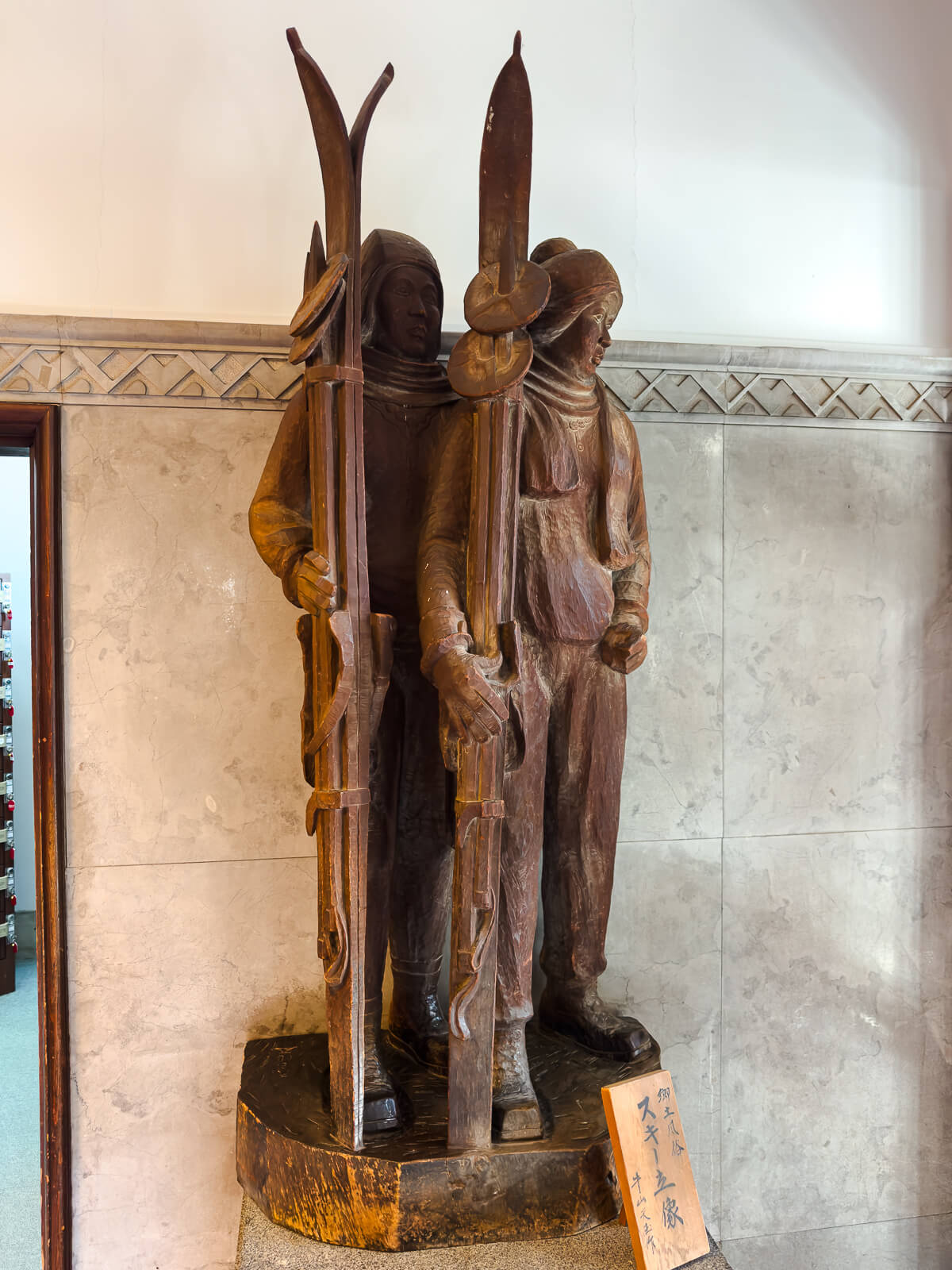 Wooden statue displayed inside Katakurakan public bathhouse in Kamisuwa Onsen