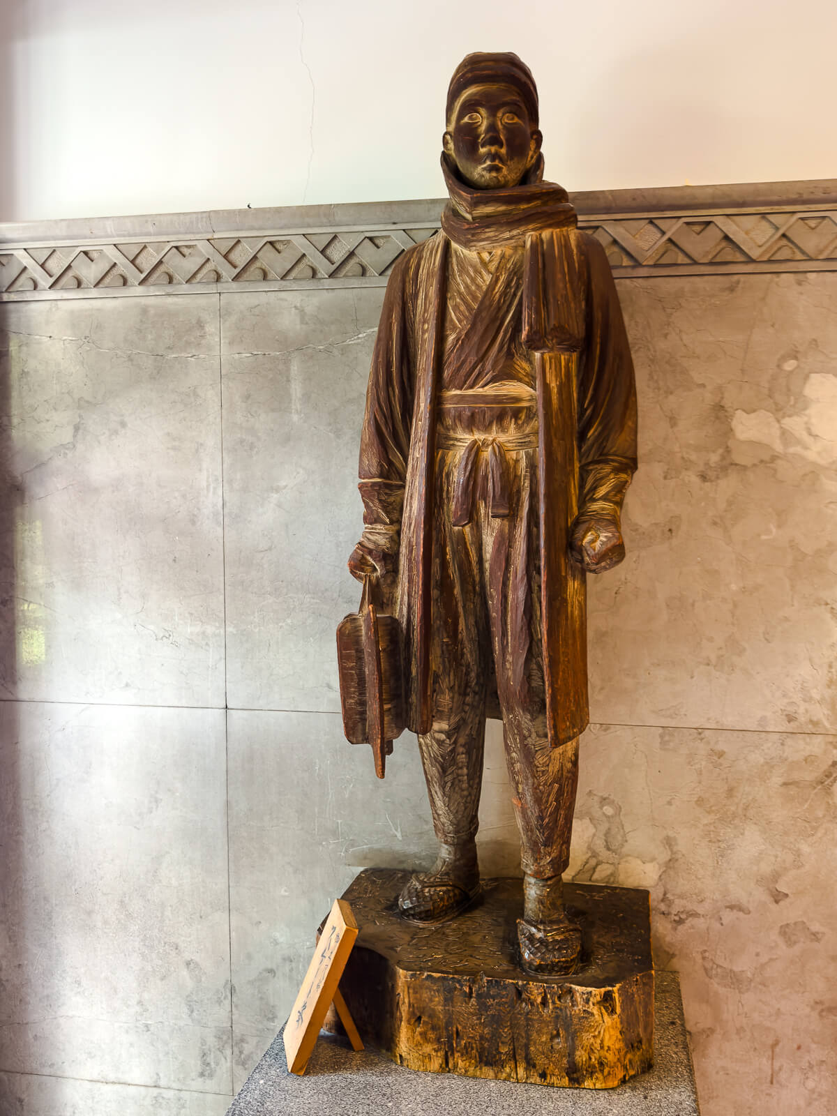 Standing wooden figure displayed inside Katakurakan public bathhouse near Lake Suwa