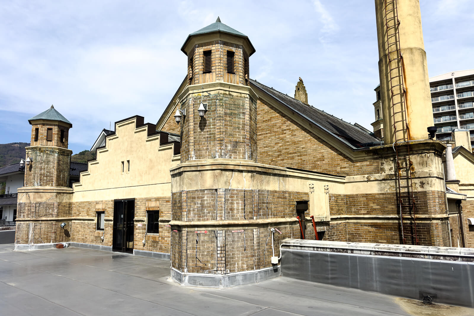 Side exterior of Katakurakan showing stonework and tower details near Lake Suwa