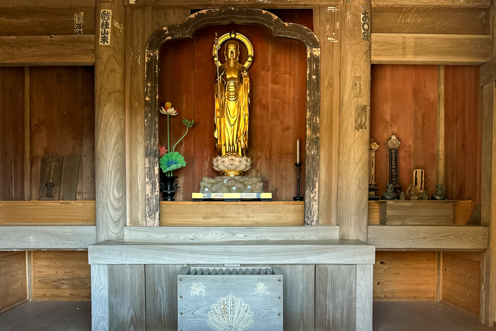 Standing Jizo statue displayed inside a wooden alcove at Jizodo in Kencho-ji Temple