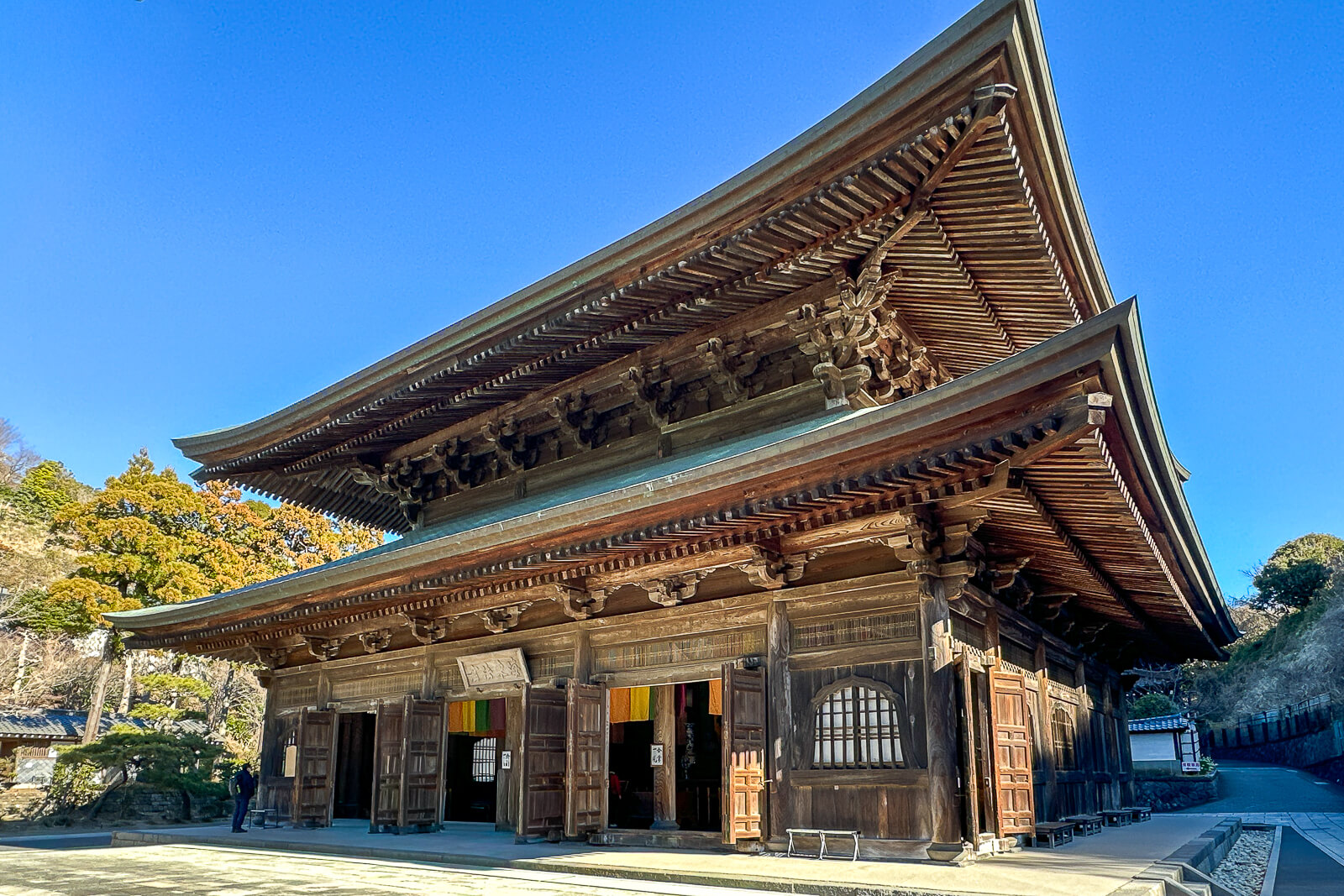 Wooden Hatto lecture hall beneath a clear blue winter sky at Kencho-ji Temple