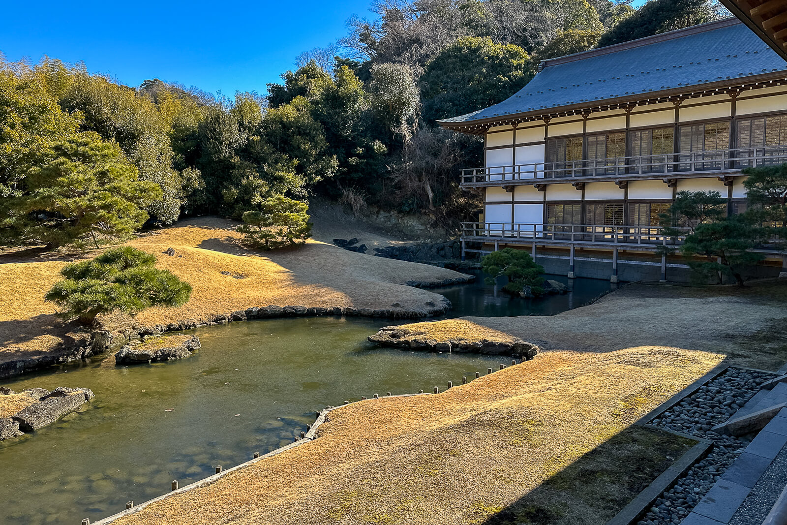 Pond garden and wooden temple hall within the inner grounds of Kencho-ji Temple