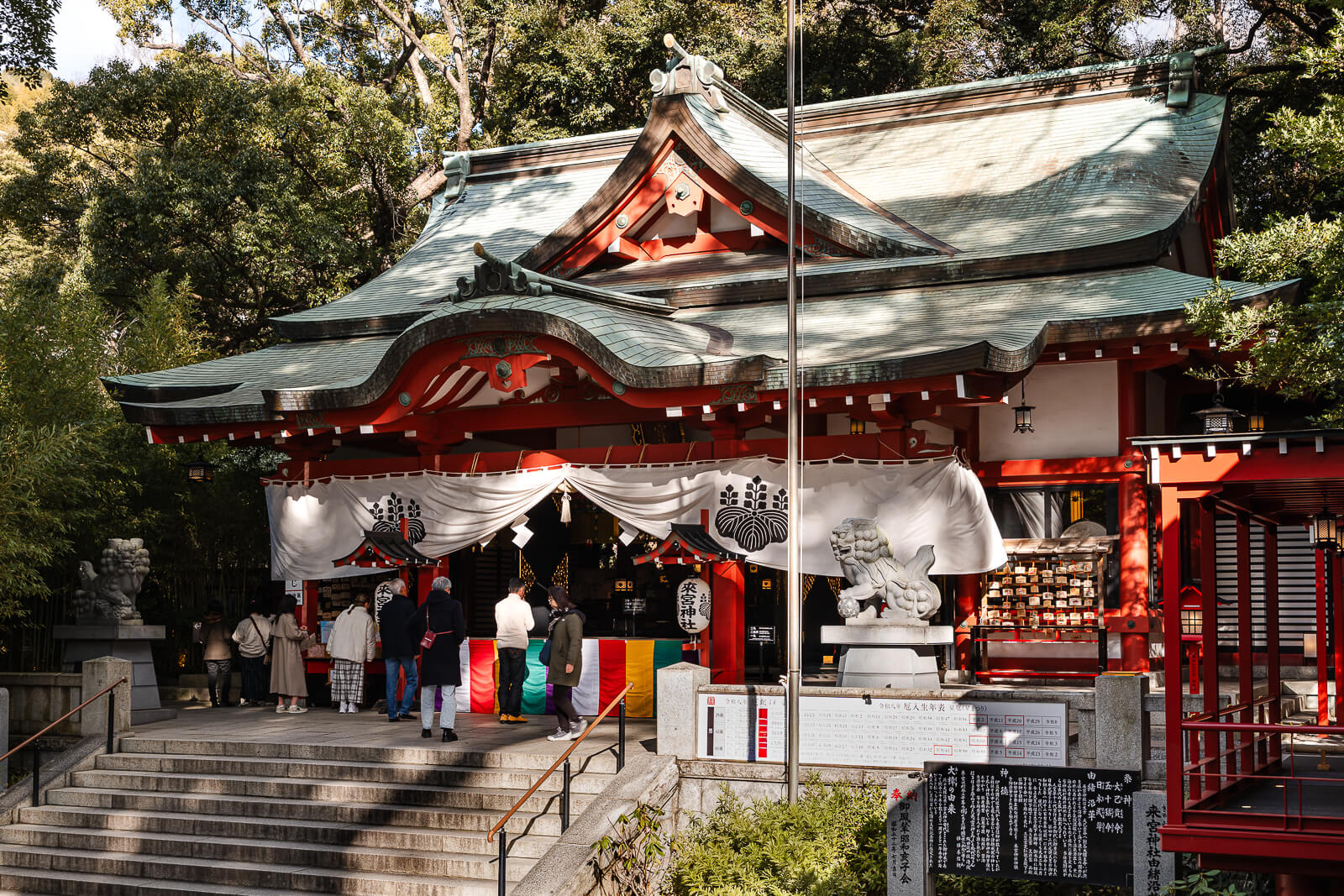Kinomiya Shrine in Atami with visitors standing before the main shrine building surrounded by trees.