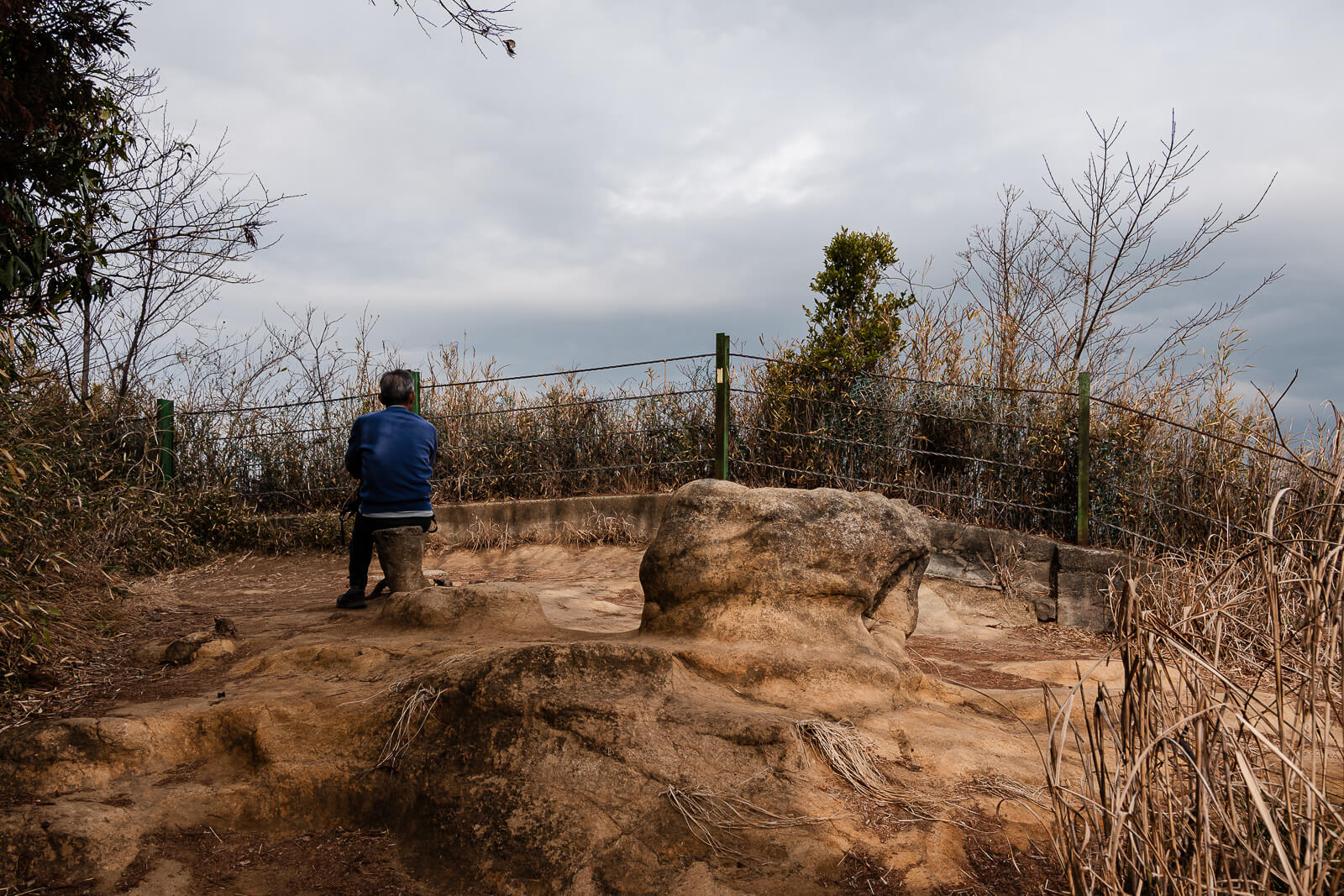 Hiker standing on exposed rocky terrain along the Ten-en Hiking Course in winter