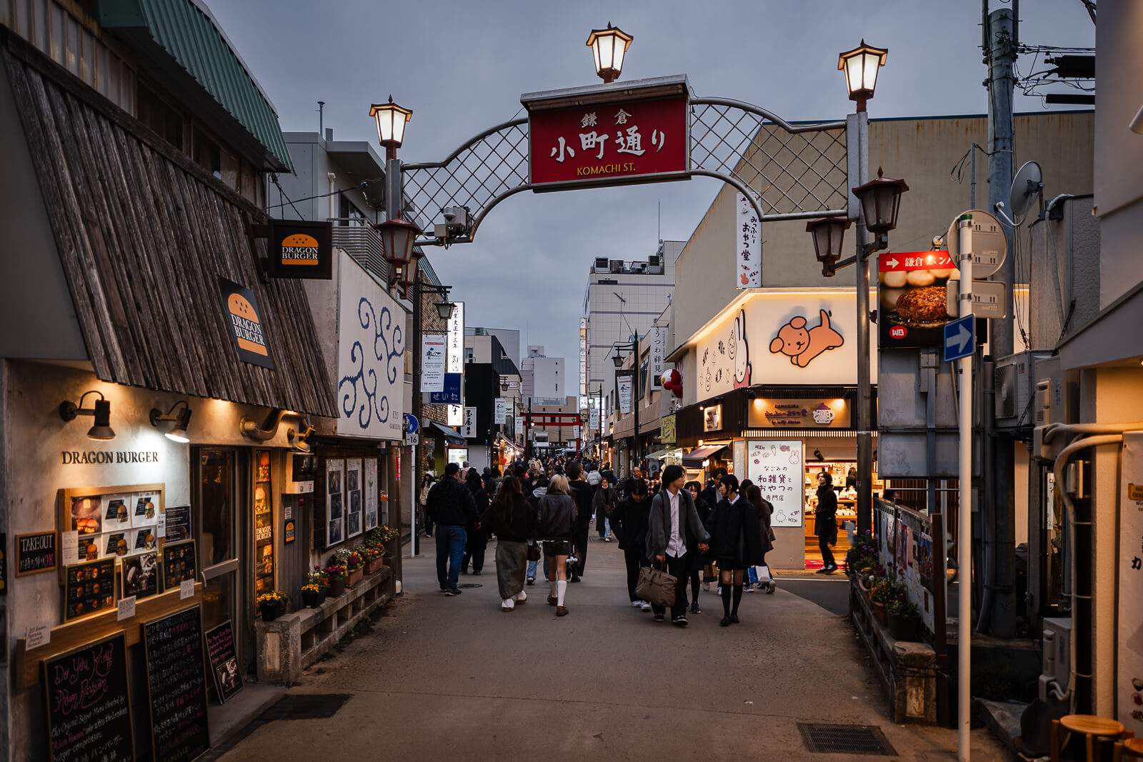 Pedestrians walking between shops and restaurants along Komachi-dori in central Kamakura during the evening