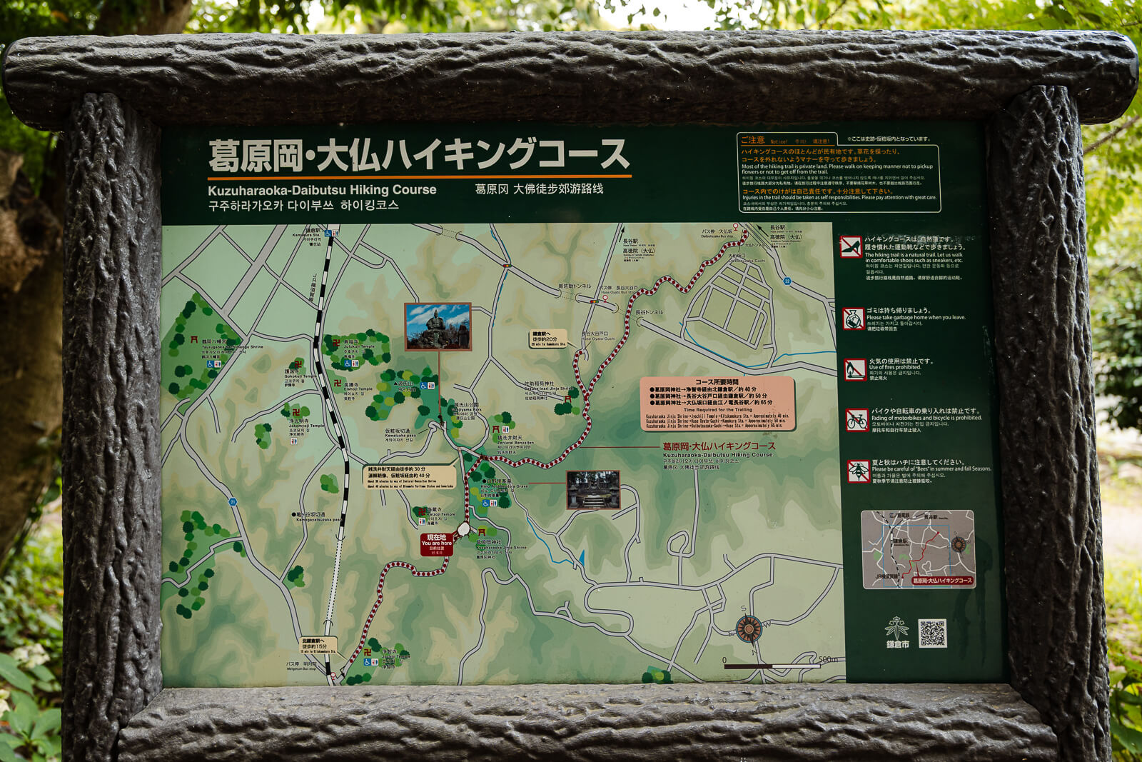 A Genjiyama Hiking Course map stands beside Kuzuharaoka Shrine in Kamakura