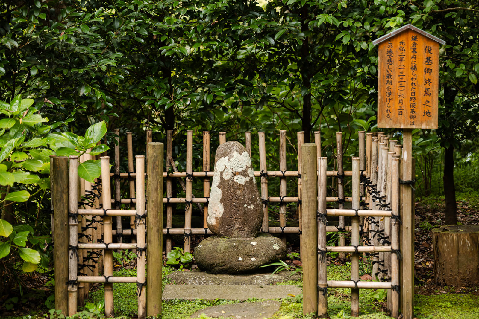 A bamboo enclosure surrounds the stone marking Hino Toshimoto’s execution site beside the main shrine