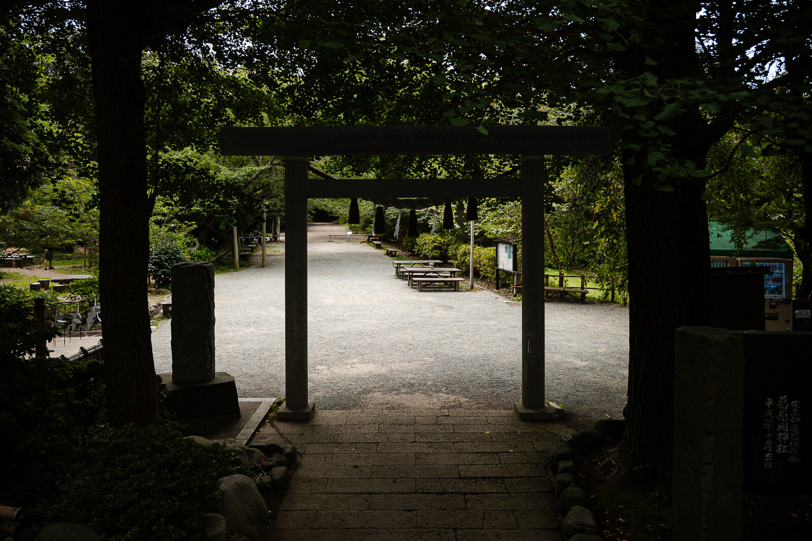 A stone torii frames the path from Kuzuharaoka Shrine toward Hino Toshimoto’s grave