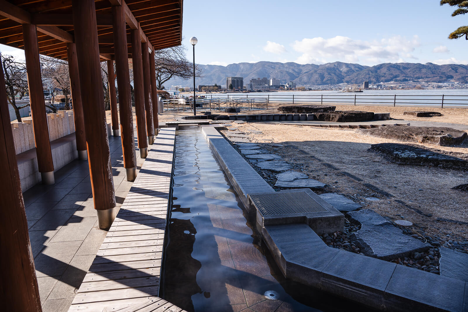 Footbath channel beneath the wooden pavilion beside Lake Suwa