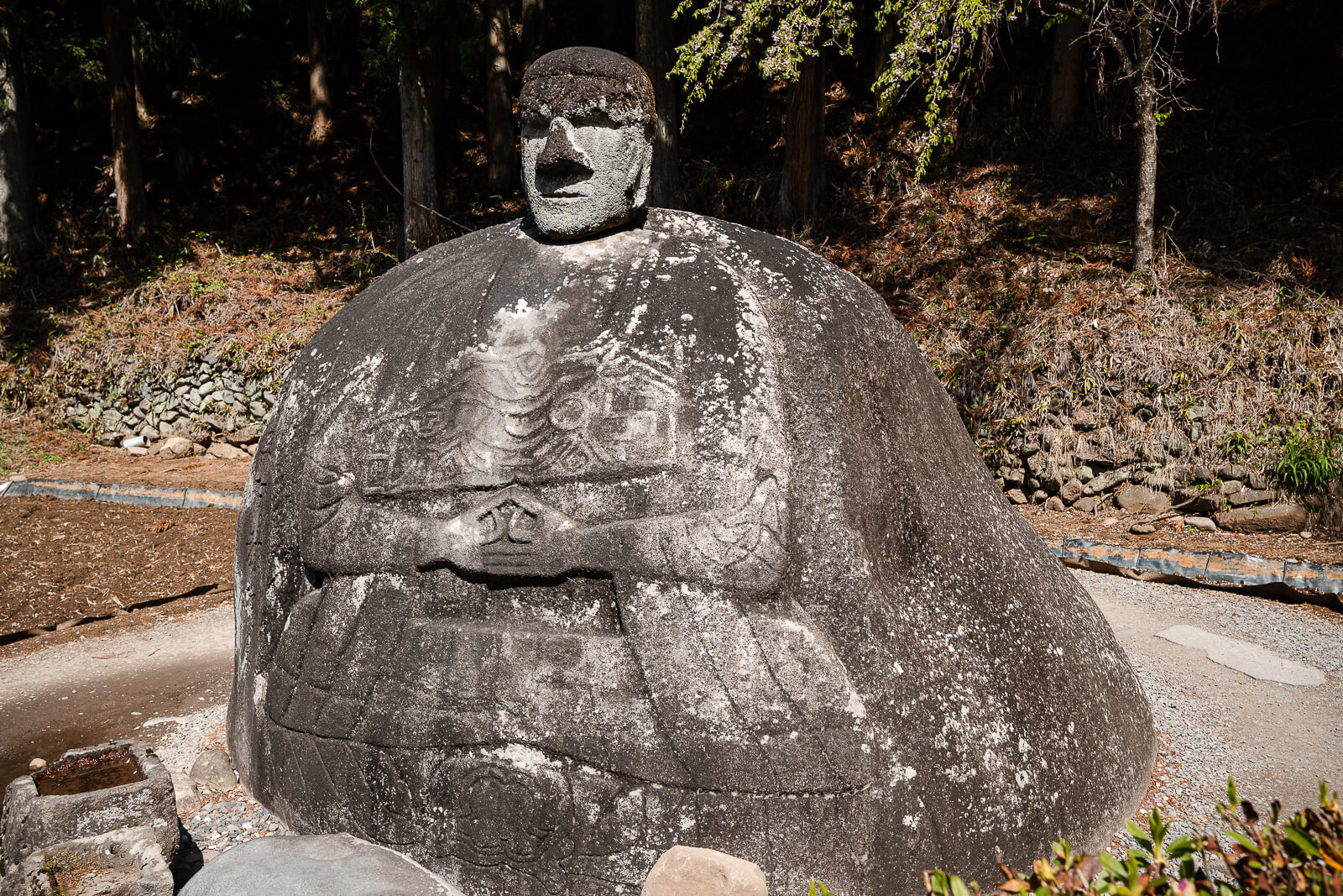 Upper body and carved markings on Manji Stone Buddha in Shimosuwa.