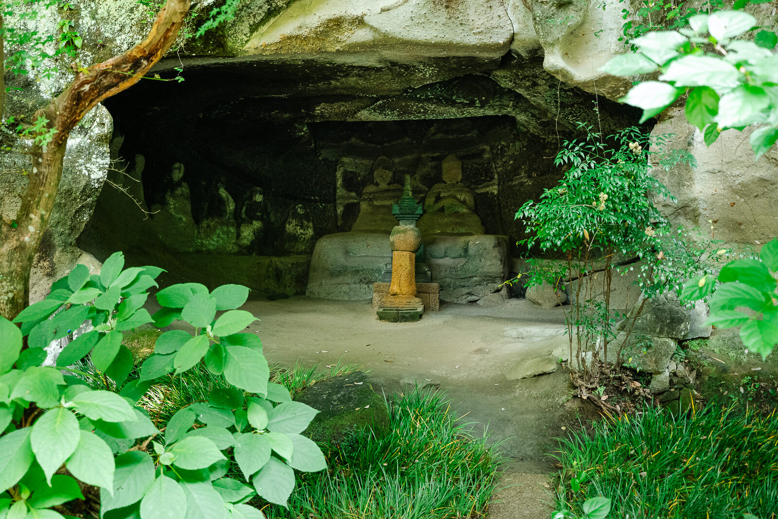 Stone Buddhist figures inside a rock-cut chamber at Meigetsu-in Temple