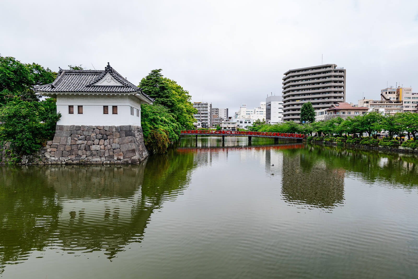Odawara Castle moat with city buildings in the background in Odawara, Kanagawa