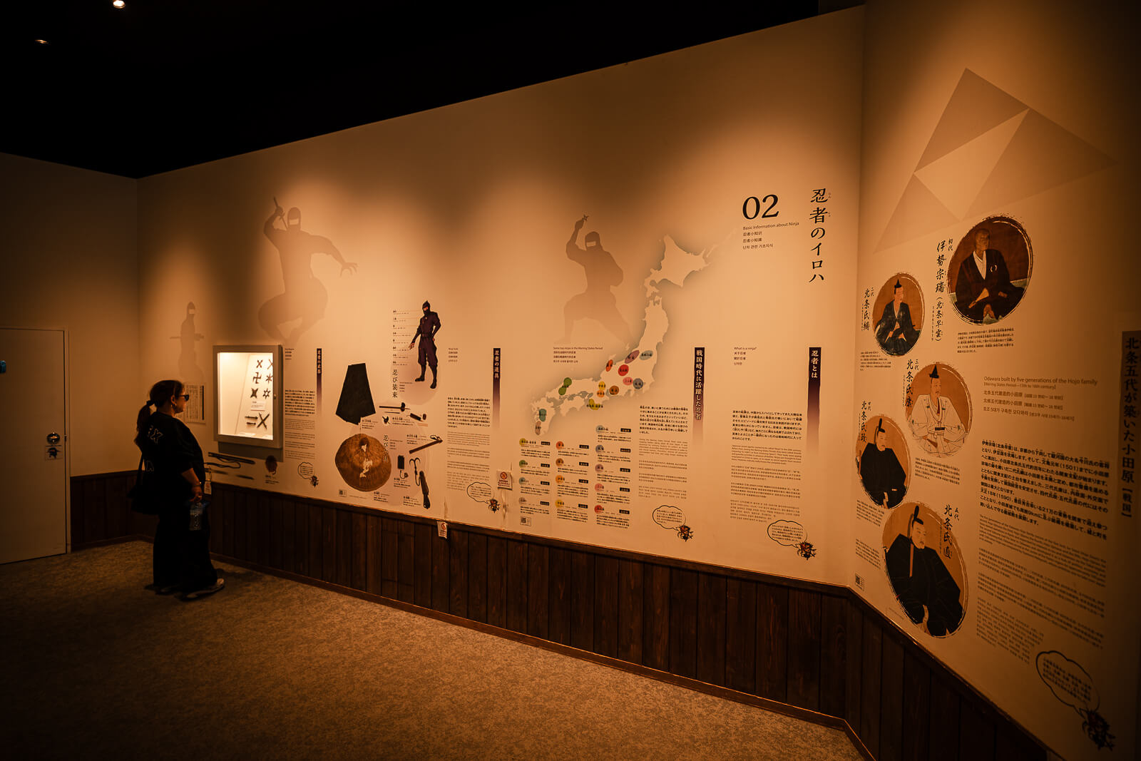 Long interior exhibit wall with ninja history and diagrams inside Odawara Castle Ninja Museum