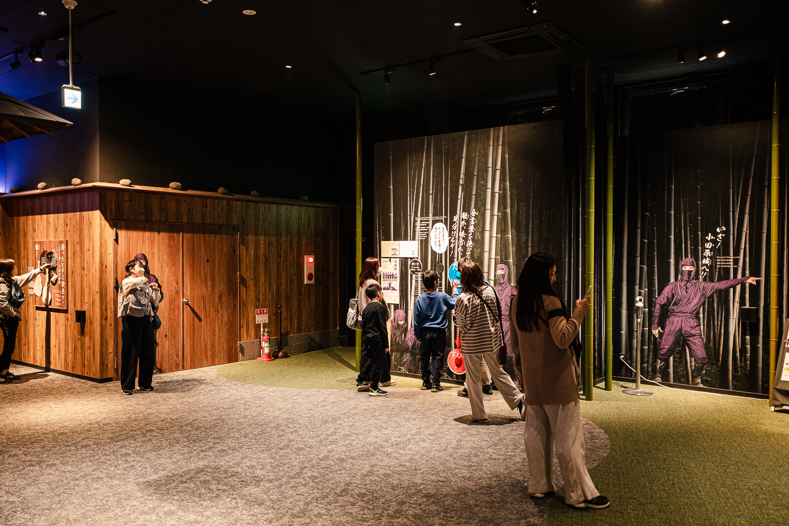 Wide interior view of ninja museum showing open activity space and wooden structures