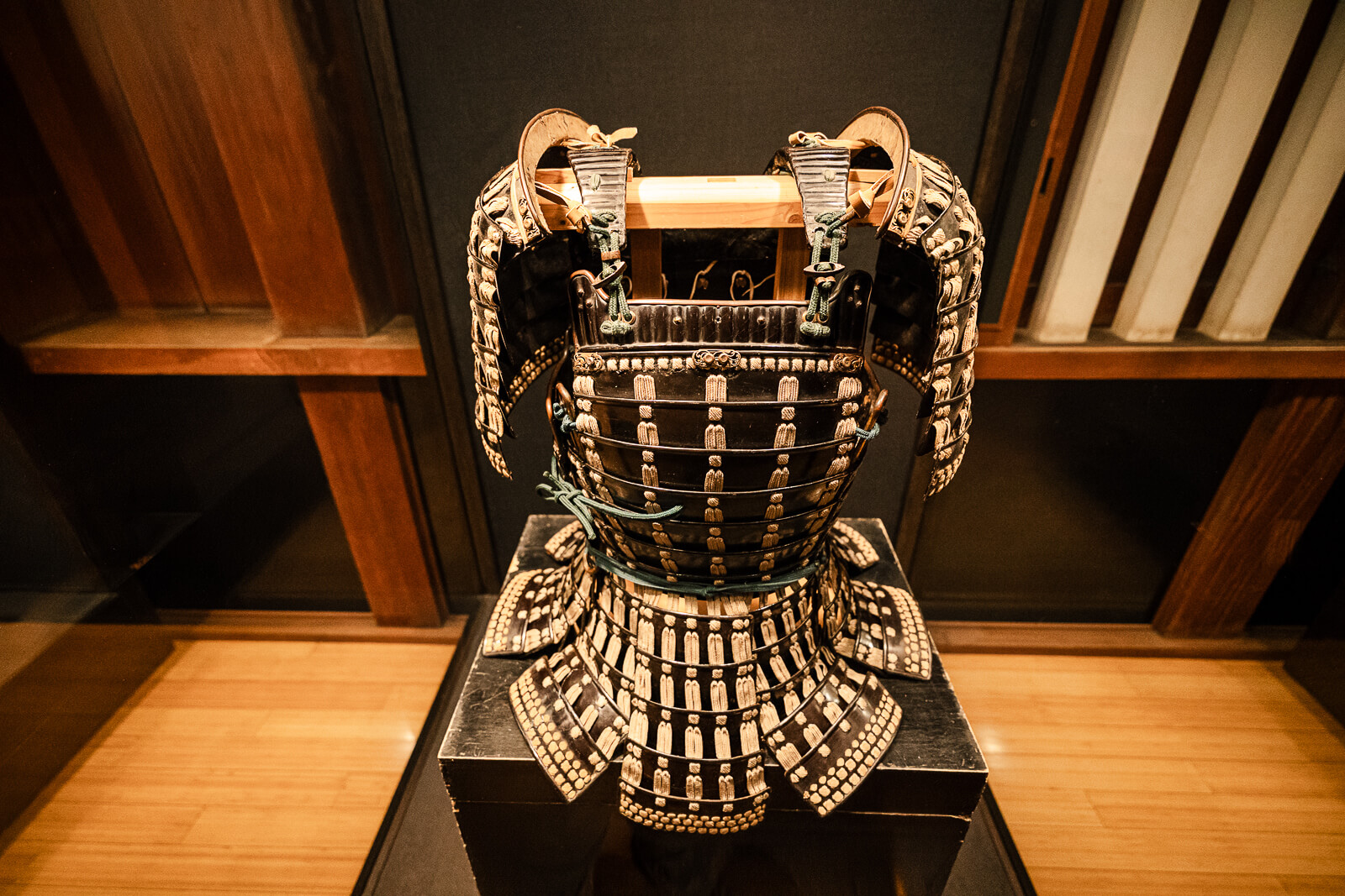 Samurai armor torso display under wooden ceiling inside Odawara Castle Samurai Museum