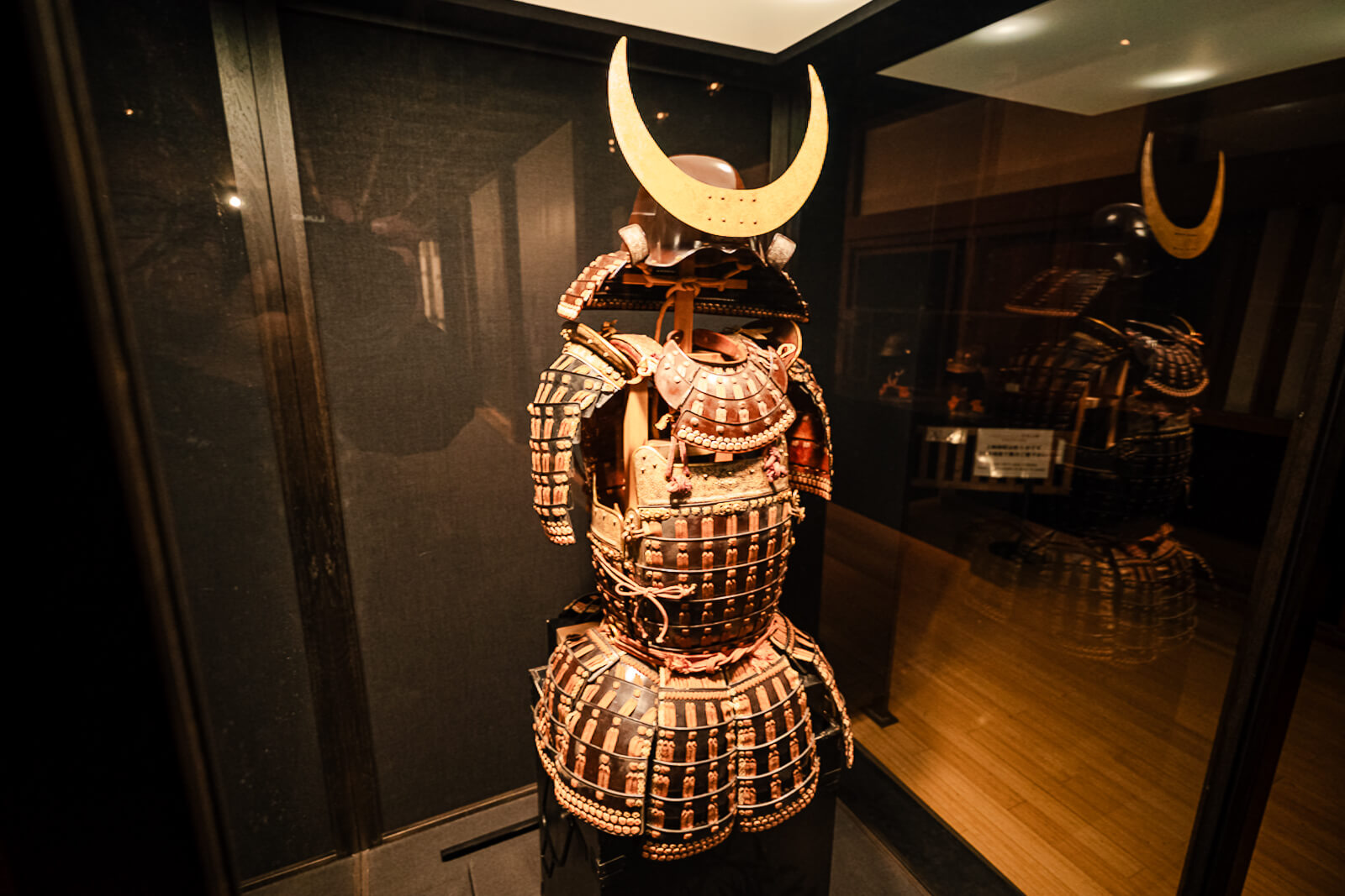 Full samurai armor standing display inside dim gallery at Odawara Castle Samurai Museum