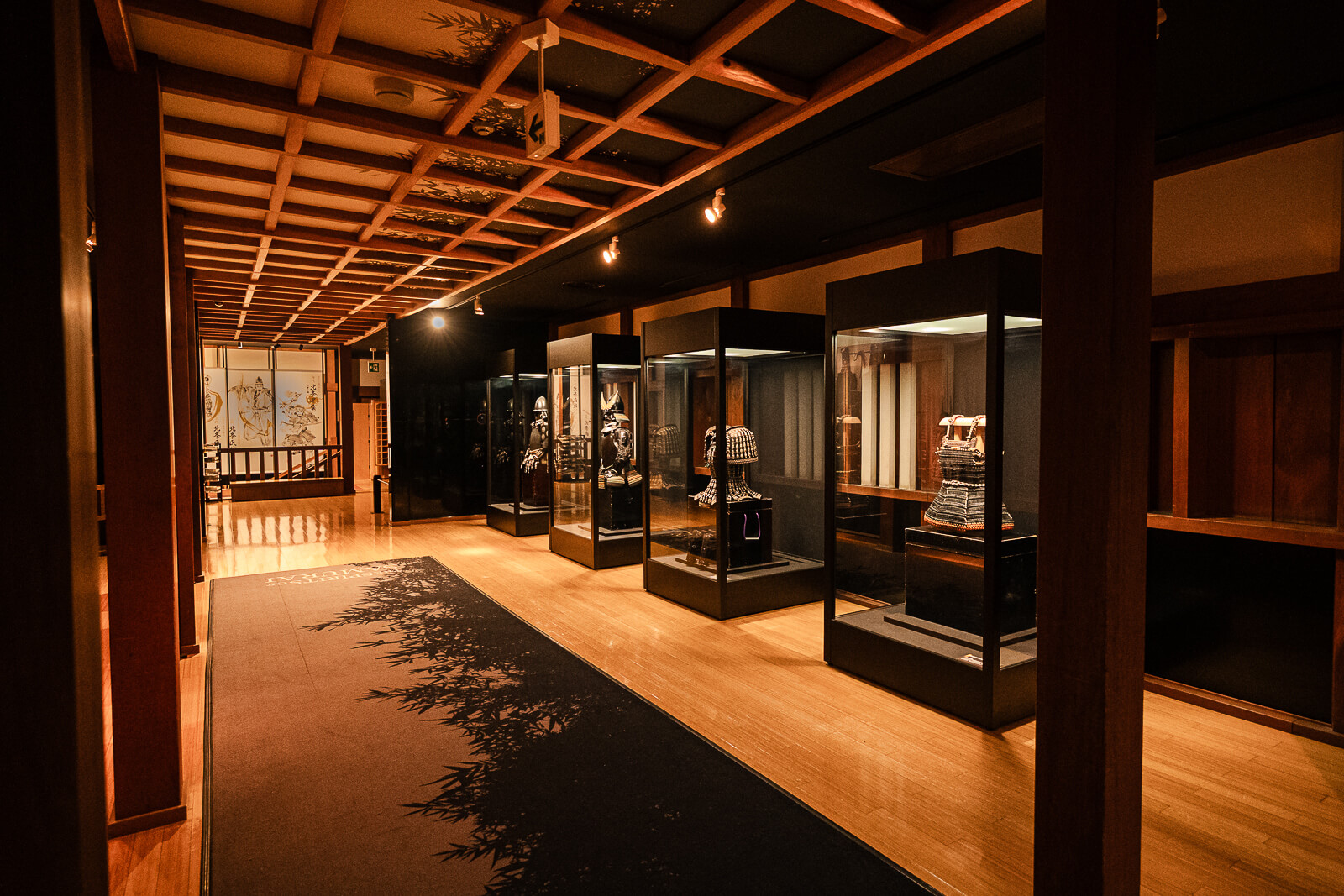 Interior museum walkway with wooden flooring and display cases at Odawara Castle Samurai Museum