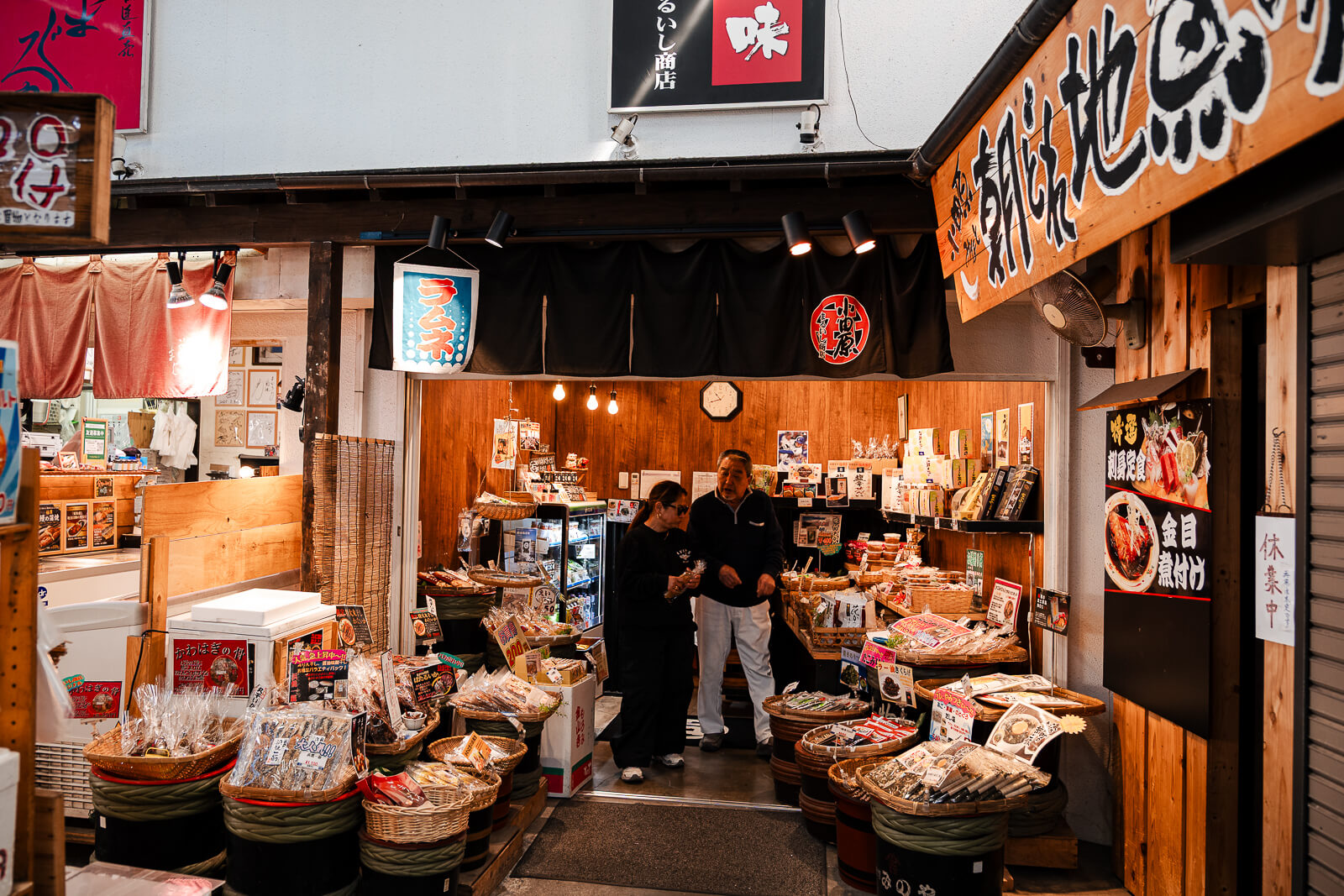 Seafood shop entrance with customers browsing fresh products in Odawara Fishing Port