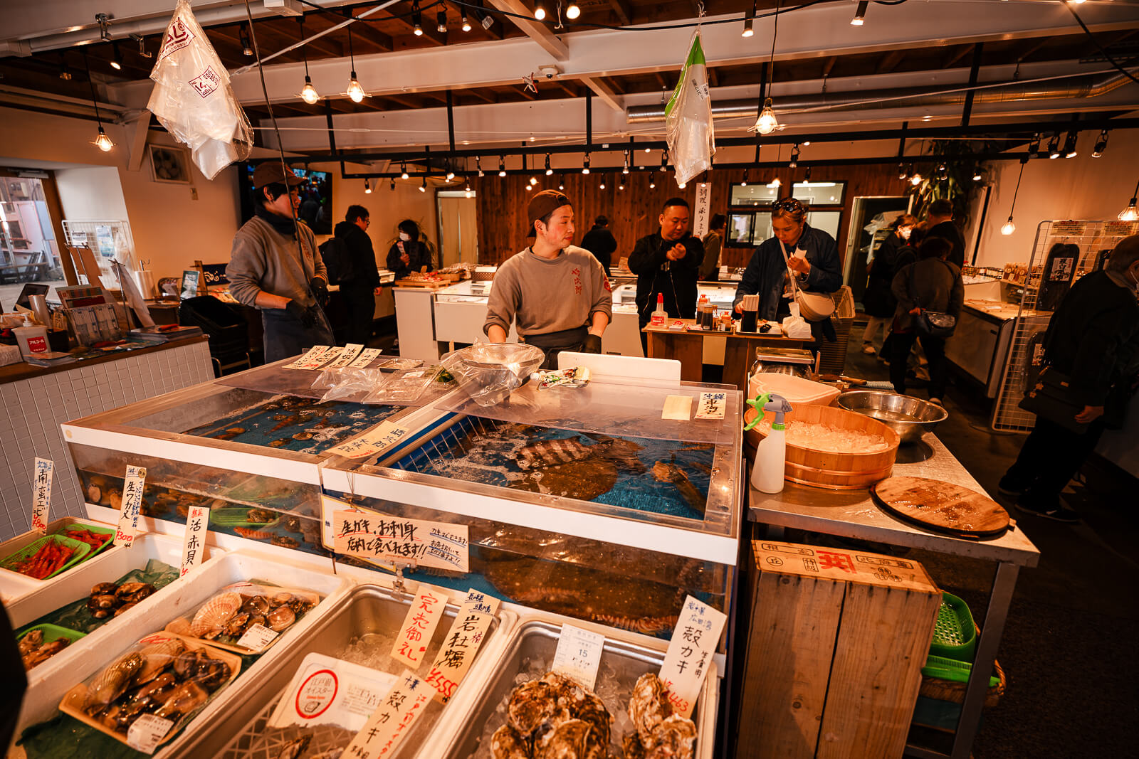 Workers preparing seafood behind a counter in Odawara Fishing Port