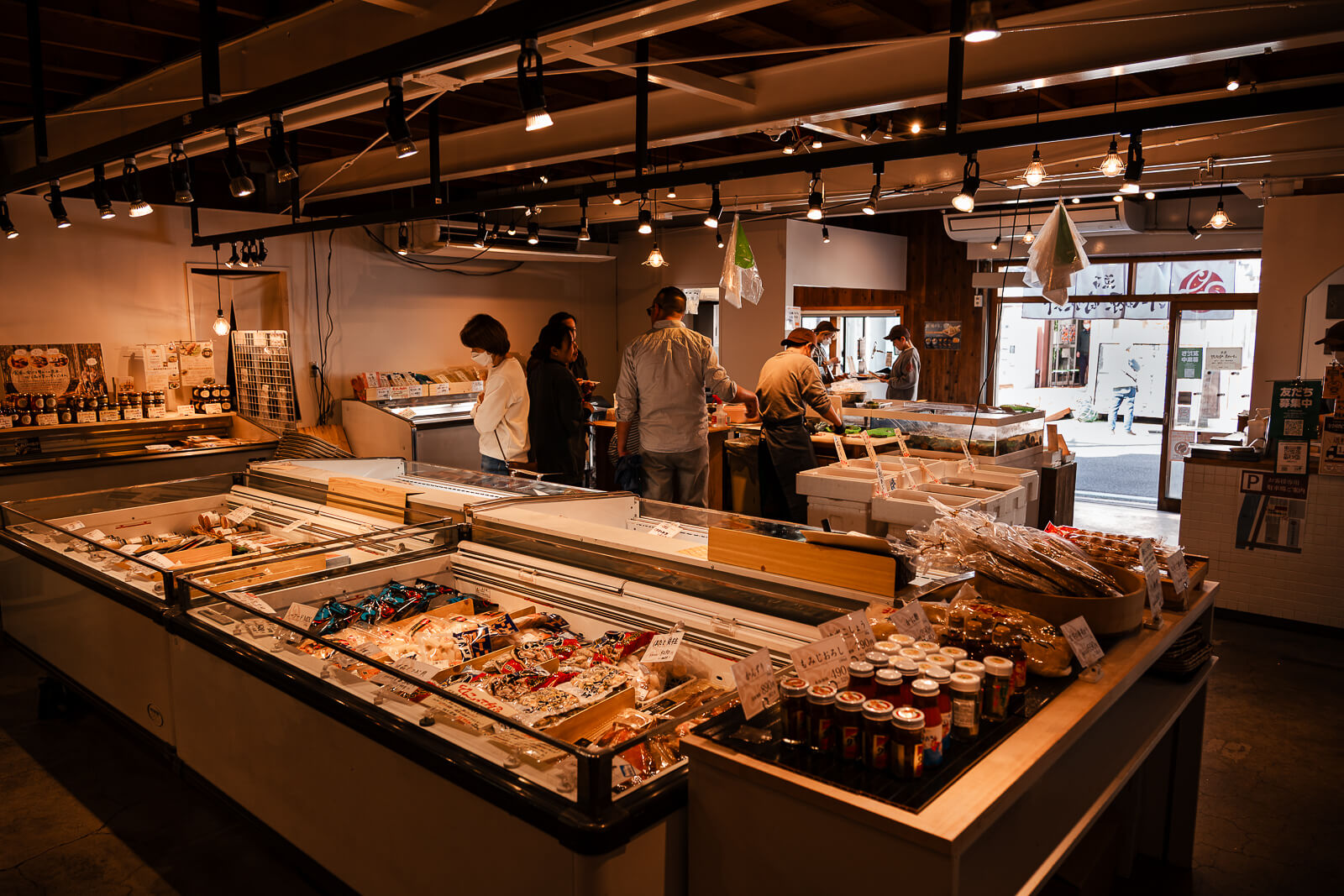 Interior seafood market display with customers browsing fresh fish in Hayakawa