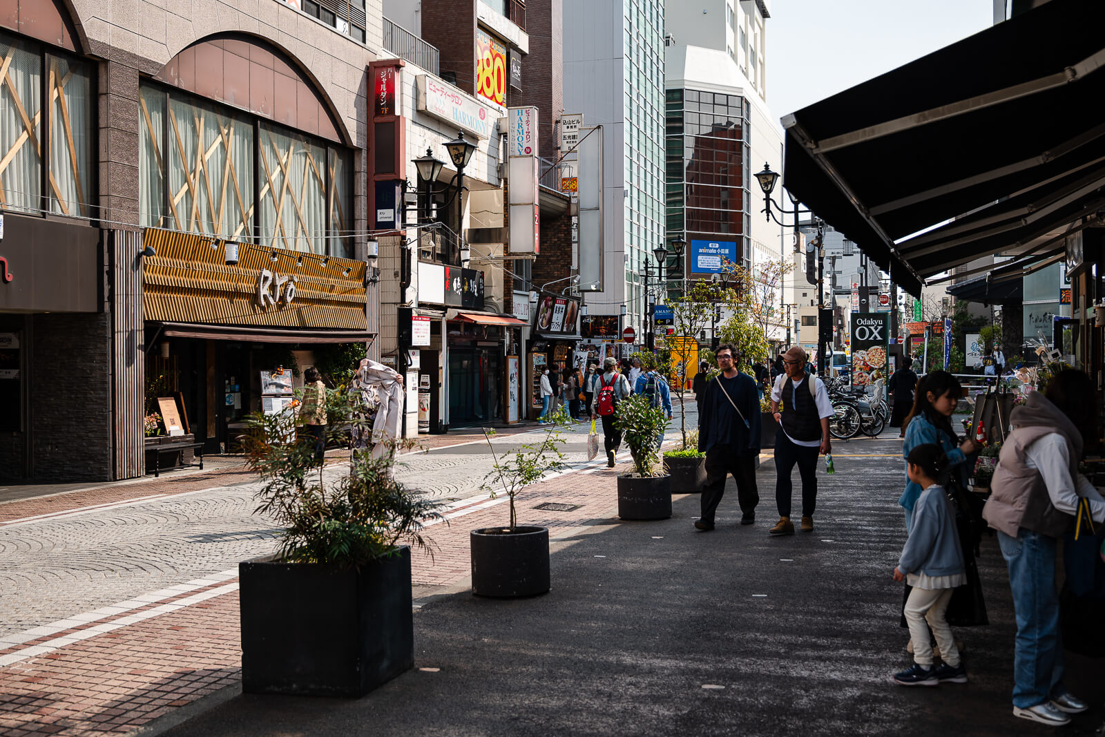 Pedestrian walkway with planters and shops on Ohoribata Street in Odawara