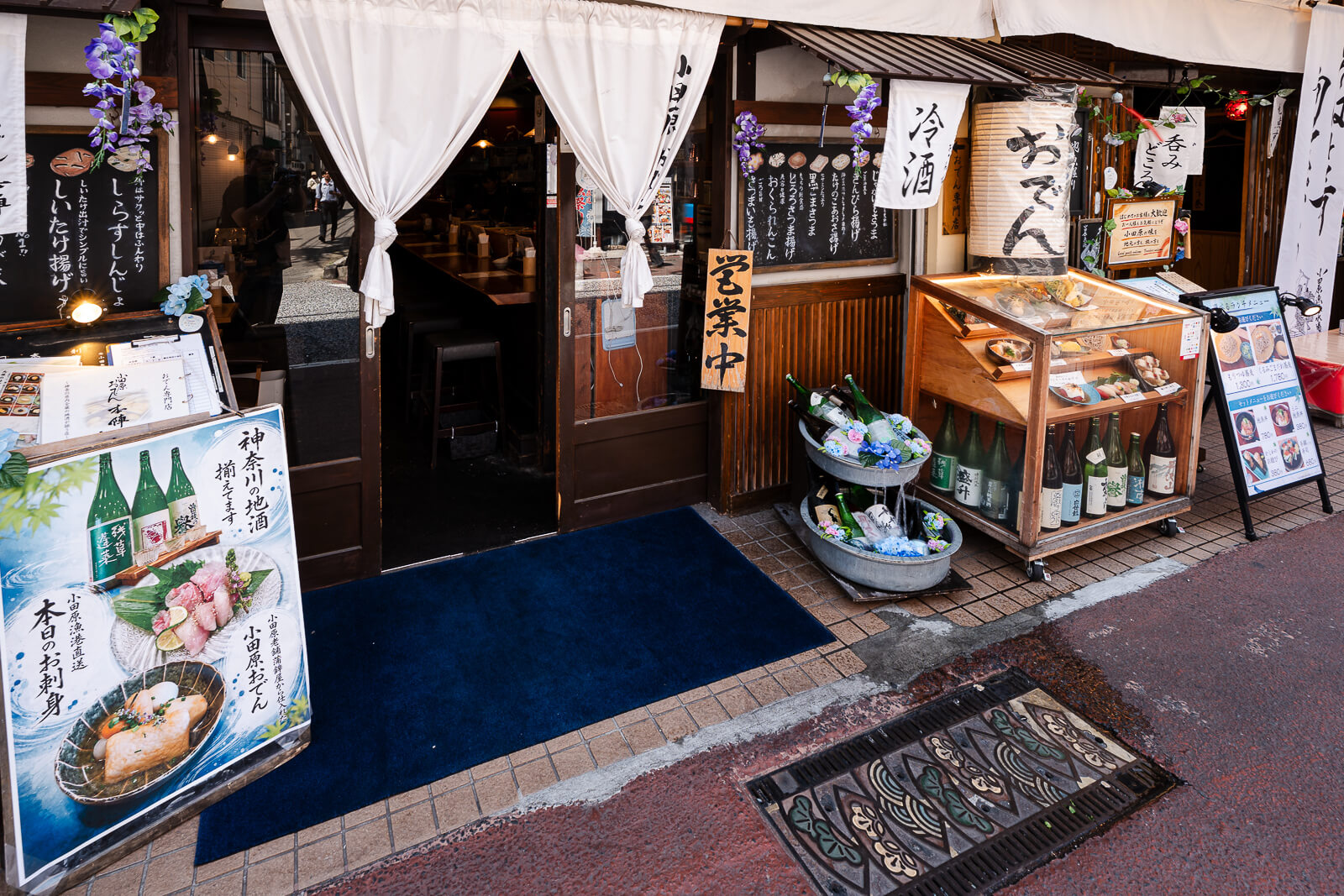 Restaurant entrance with white noren and food displays on Higashidori Shopping Street
