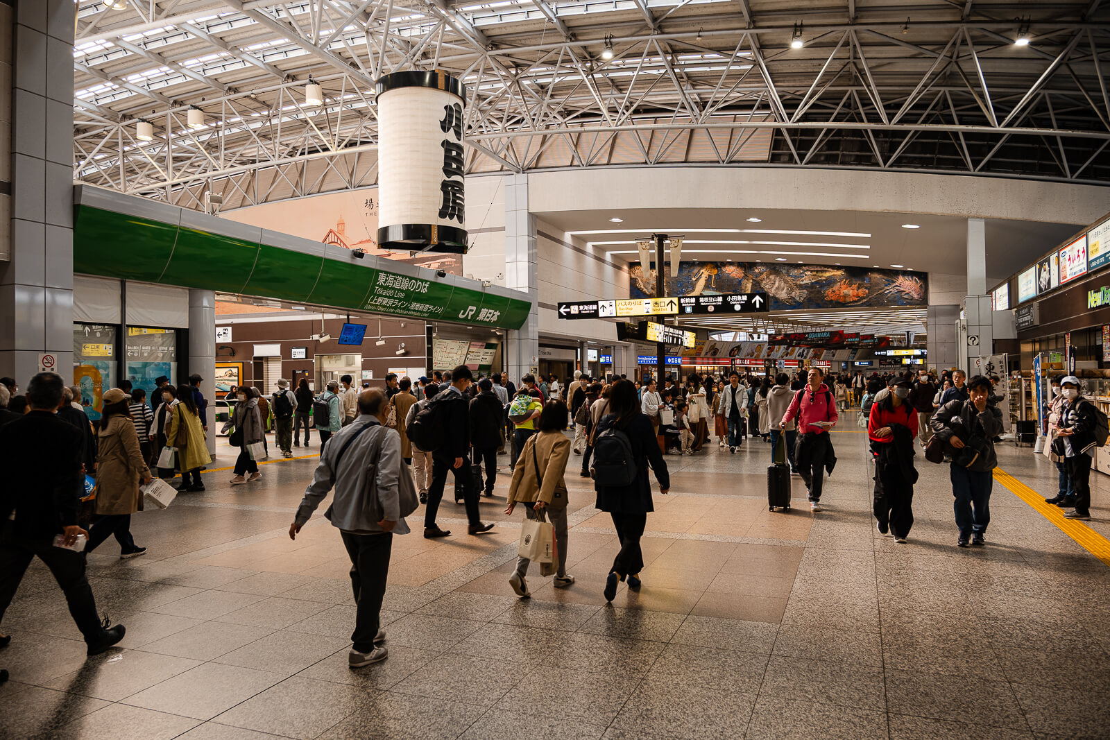 Wide interior concourse inside Odawara Station with travelers moving through the station platforms and corridors