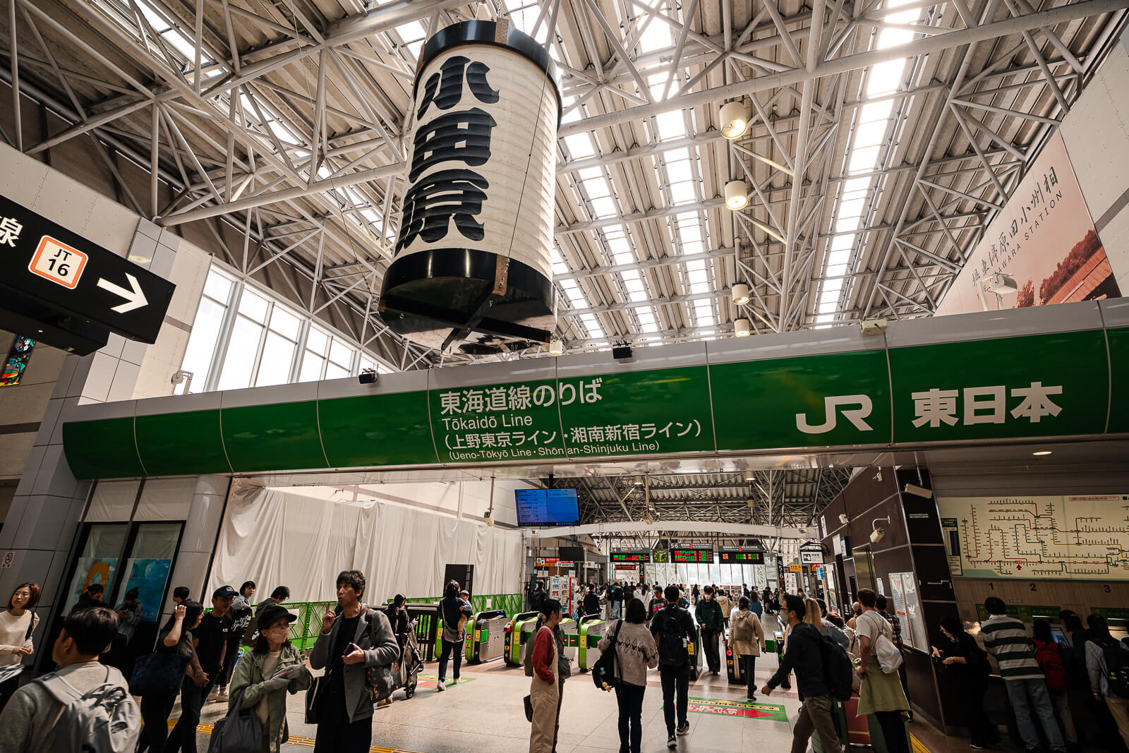 Tokaido Line entrance at Odawara Station with passengers moving through the ticket gates beneath a large Odawara lantern.
