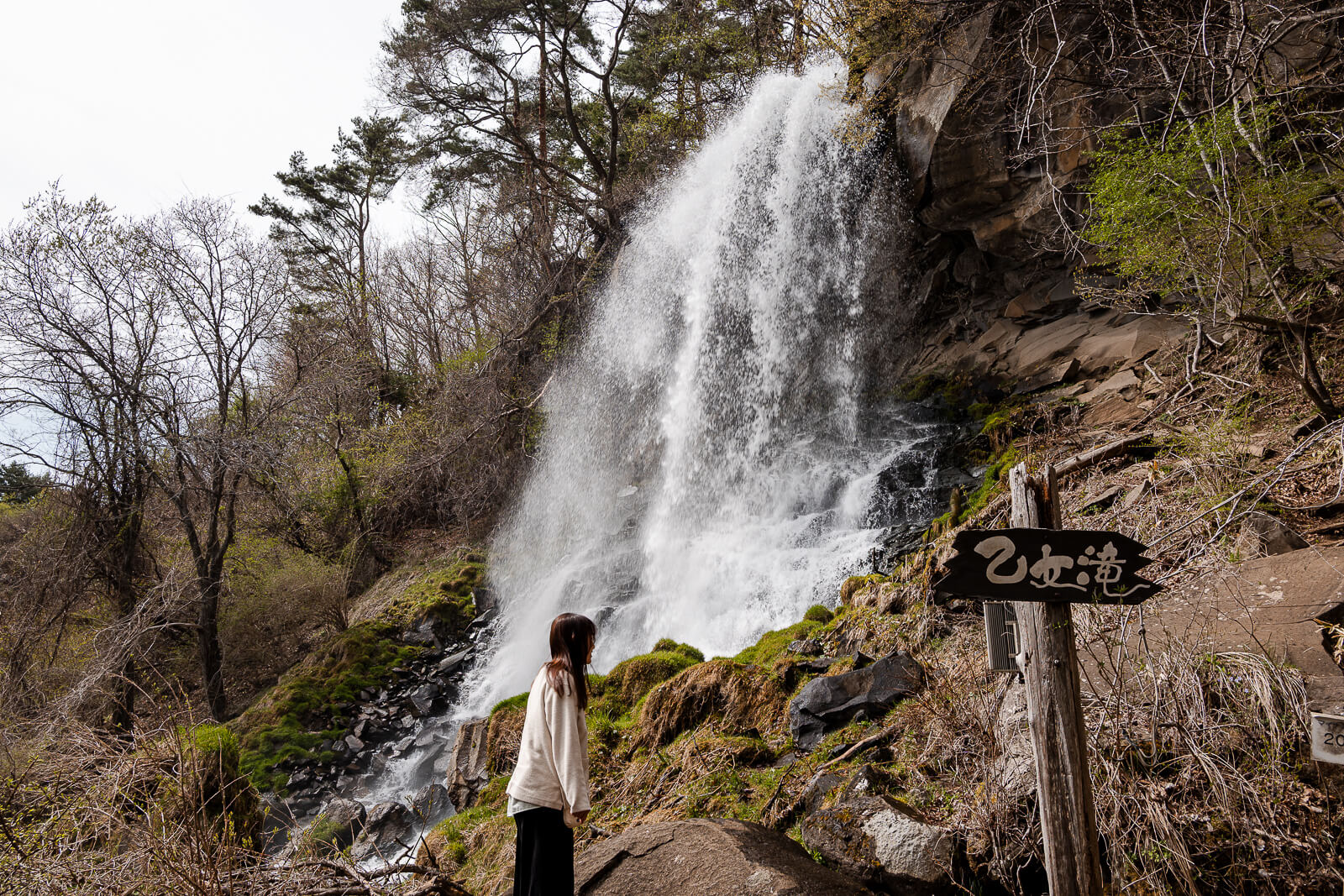 Person standing near Otome Falls showing the scale of the waterfall in Chino, Nagano